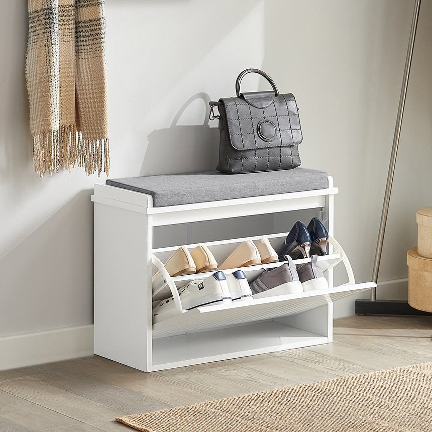 White entryway cabinet with a gray cushion on top, featuring two pull-down drawers for shoes.