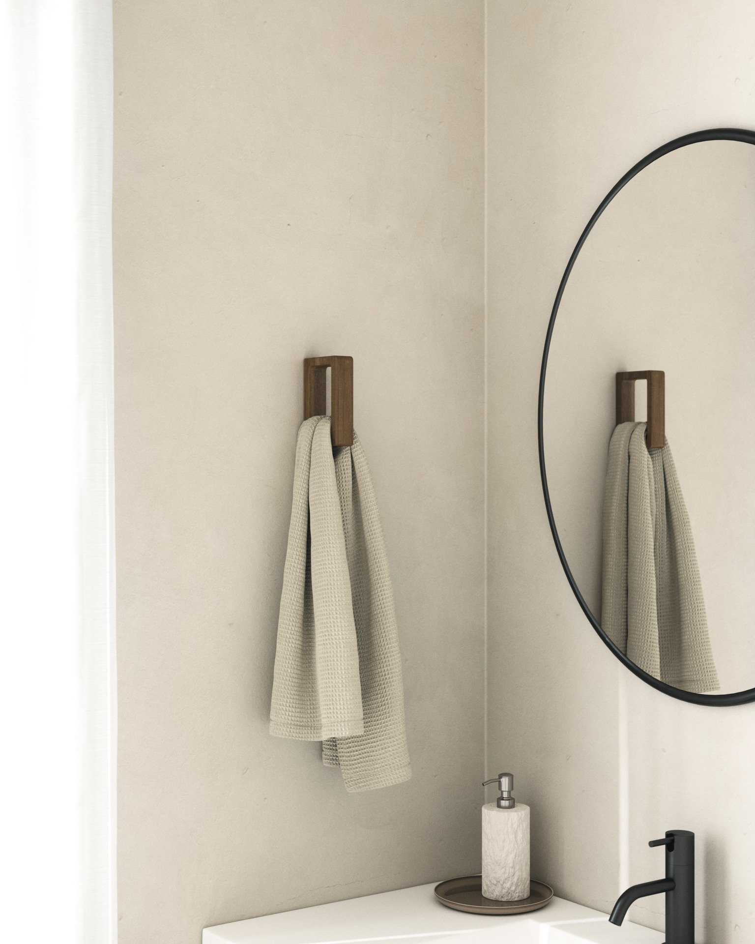 A dark walnut wood hook holding a beige waffle-weave hand towel mounted in a bathroom corner.