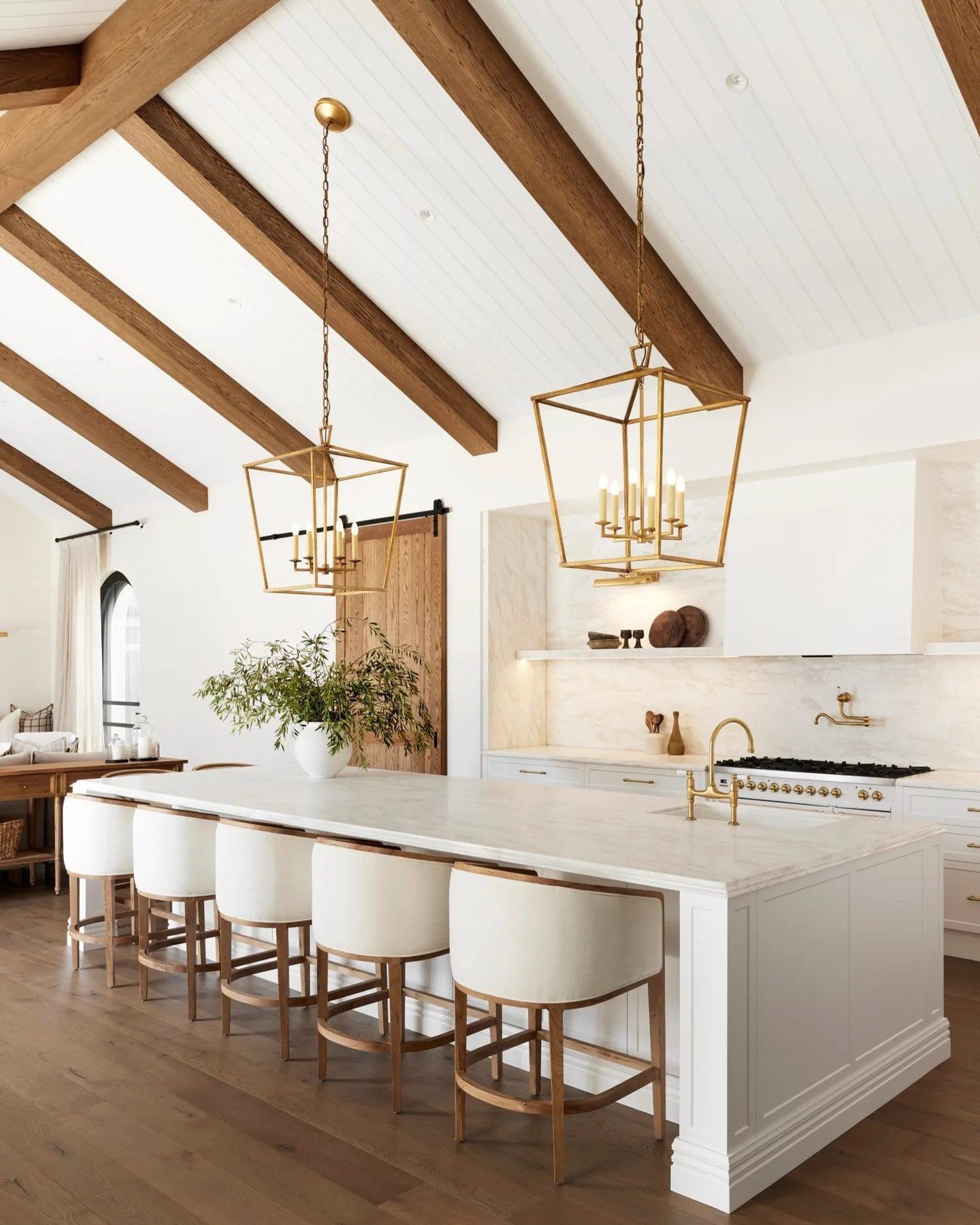 Natural woven rattan pendant light adding bohemian texture above a white kitchen island.