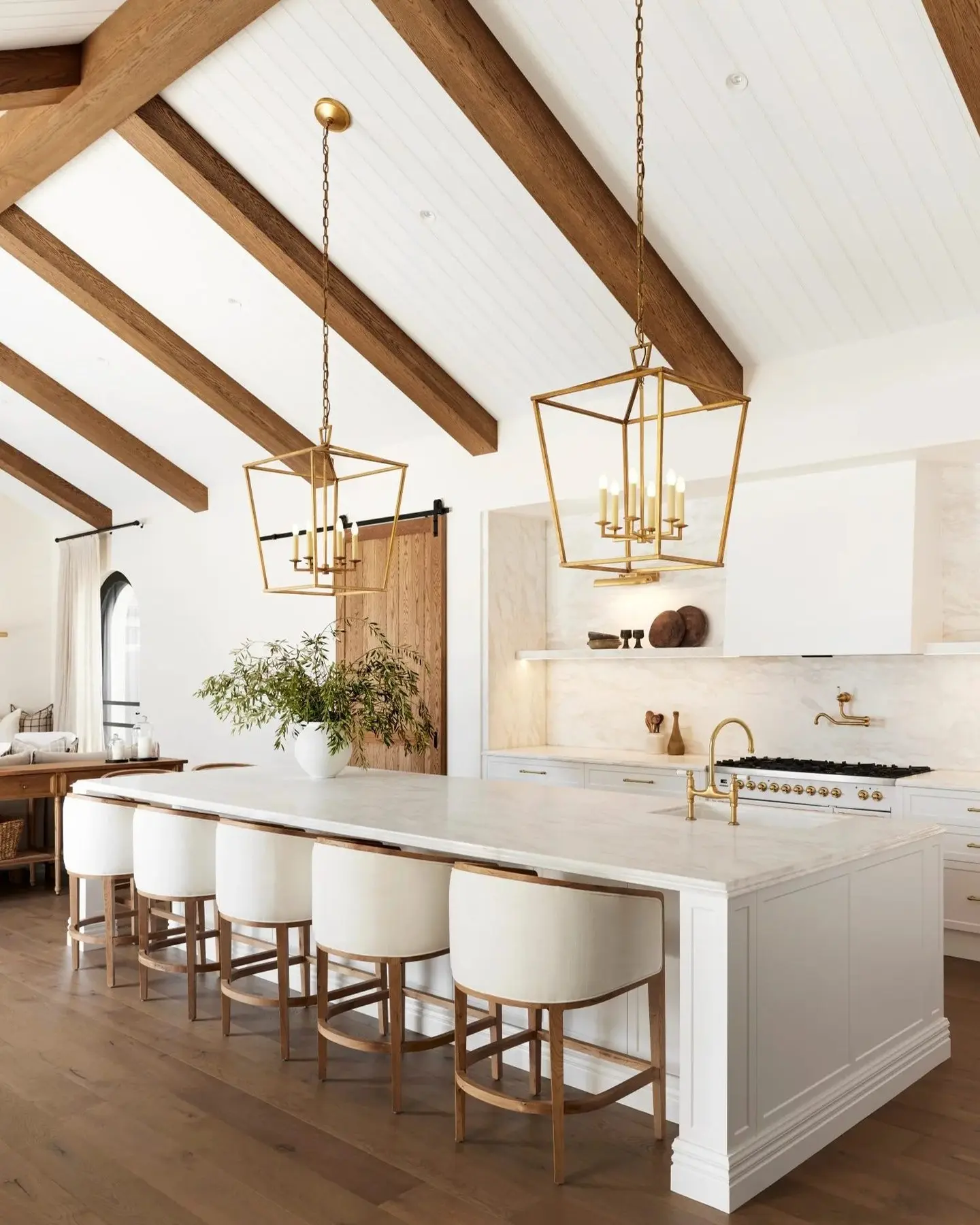 Natural woven rattan pendant light adding bohemian texture above a white kitchen island.