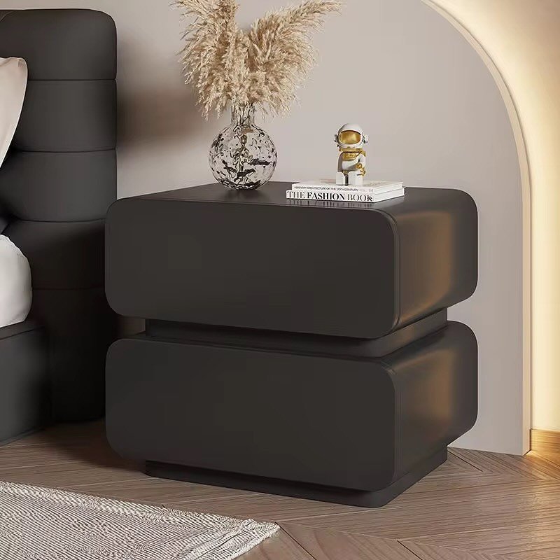 Dark gray or black nightstand with two large drawers featuring rounded, oversized fronts and a floating appearance.