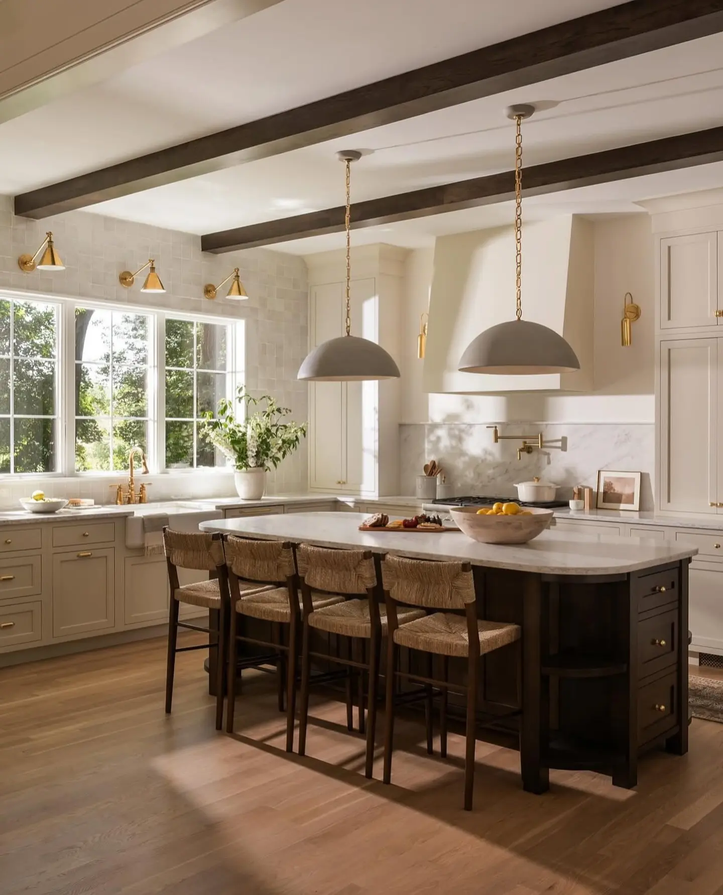 Two contrasting black exterior and gold interior drum pendants above a luxurious kitchen island.