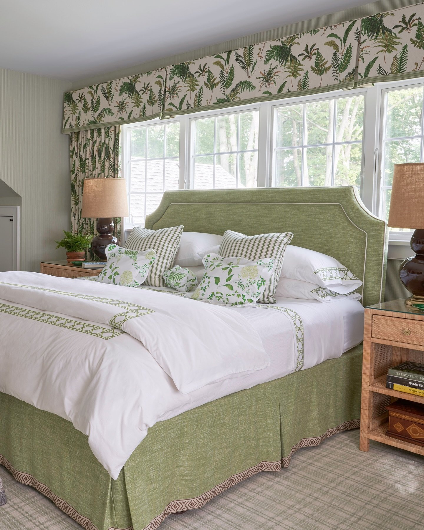 Traditional bedroom with a green upholstered headboard, matching bed skirt, and a lively fern-patterned valance.