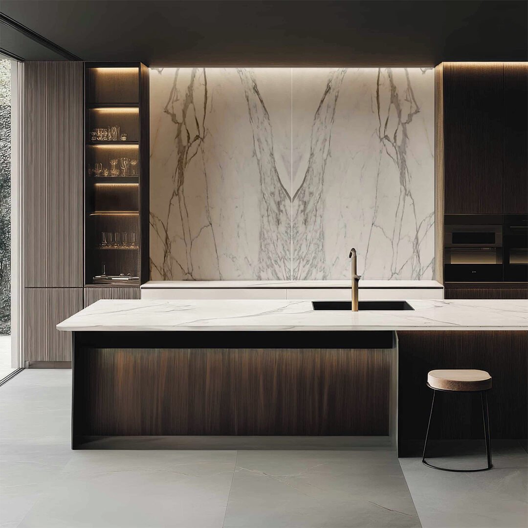 Luxurious modern kitchen featuring dark wood cabinetry, a white marble island, and a book-matched white marble backsplash dramatically lit by hidden LEDs.