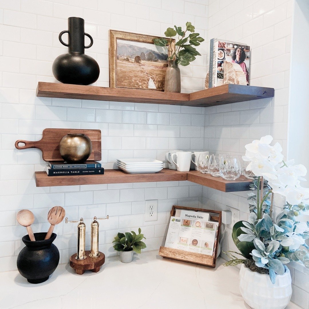Thick wooden corner floating shelves installed on a white tiled wall without visible brackets.