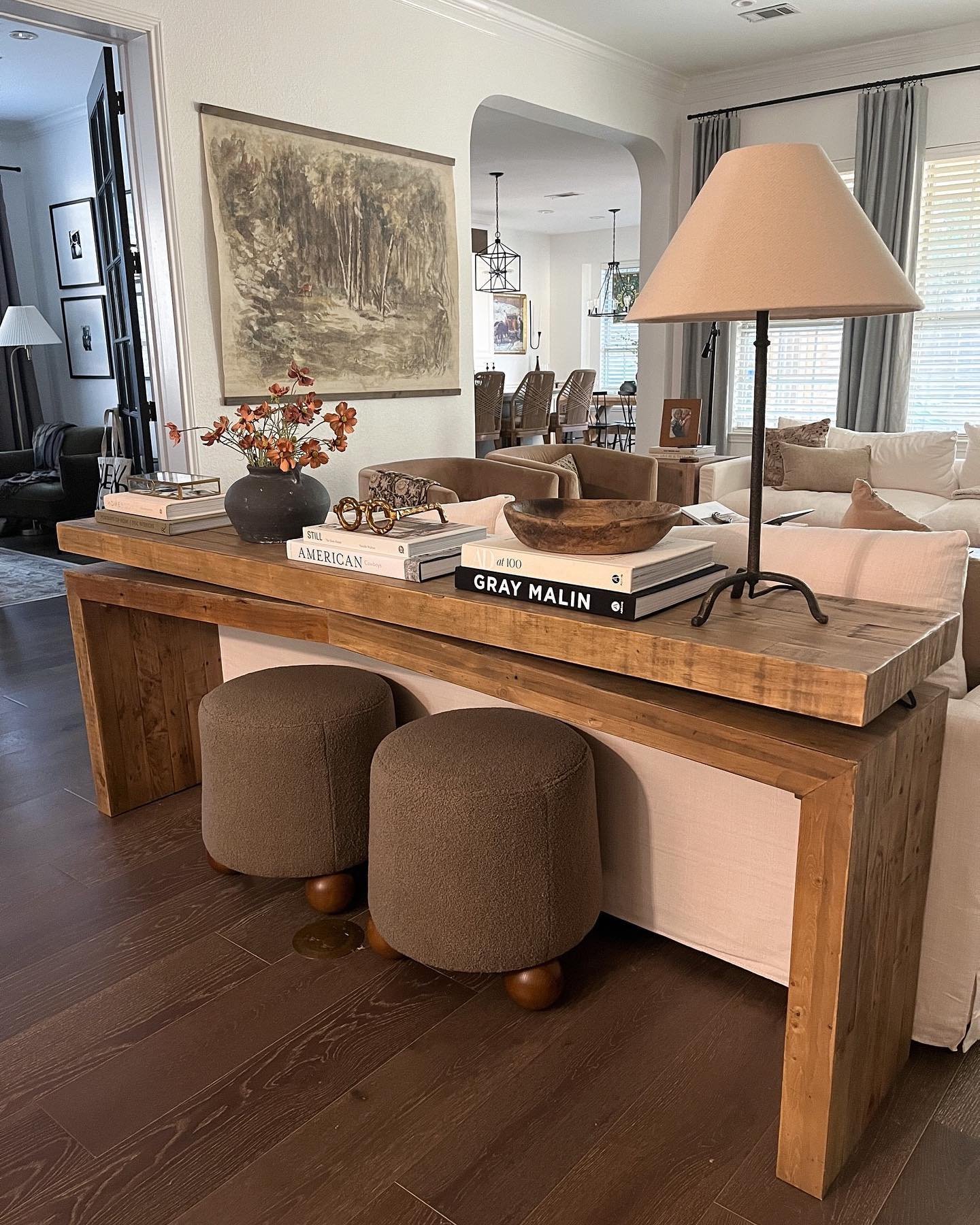 Long wooden console table styled behind a white sofa