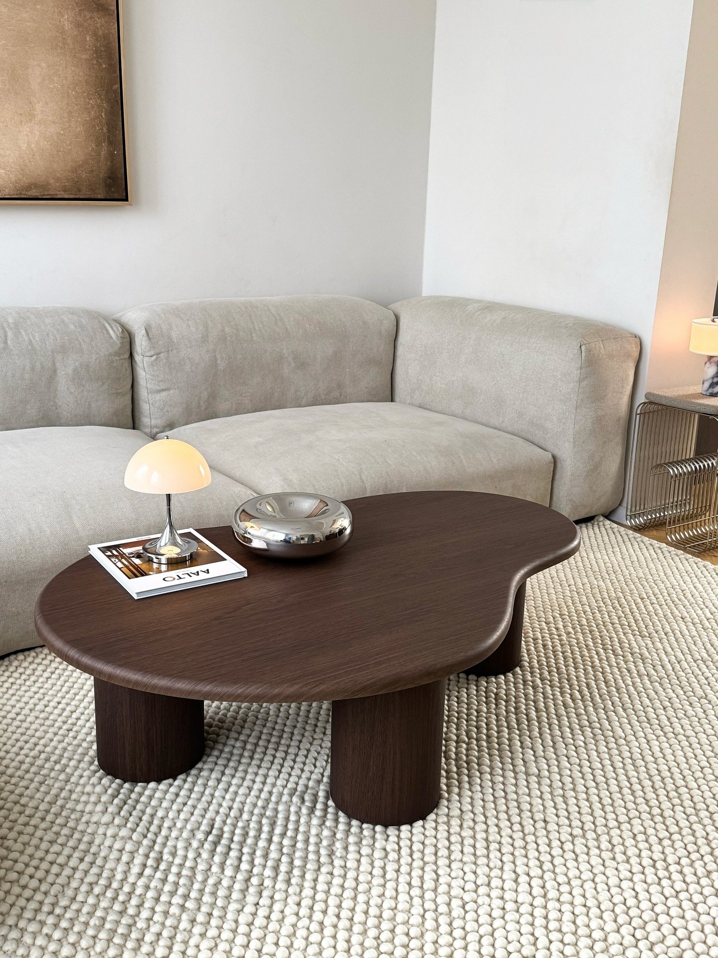 Kidney shaped dark wood coffee table with thick round legs