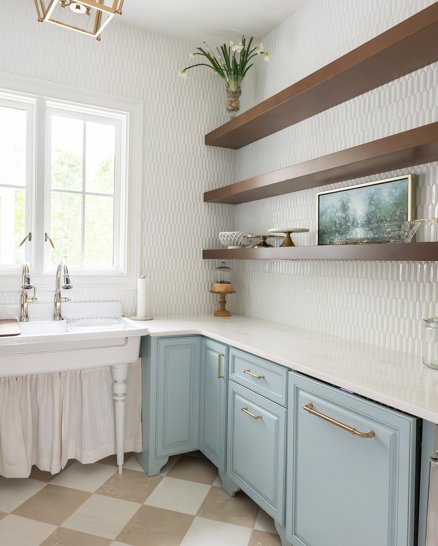Three dark wood floating shelves in a kitchen pantry corner with light blue cabinets.