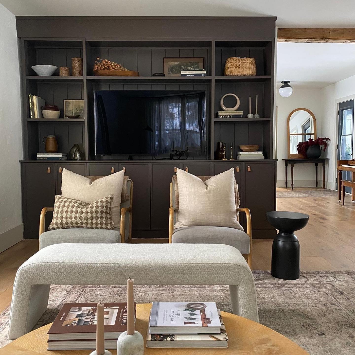 Dark charcoal built-in TV unit with open shelves and leather cabinet pulls