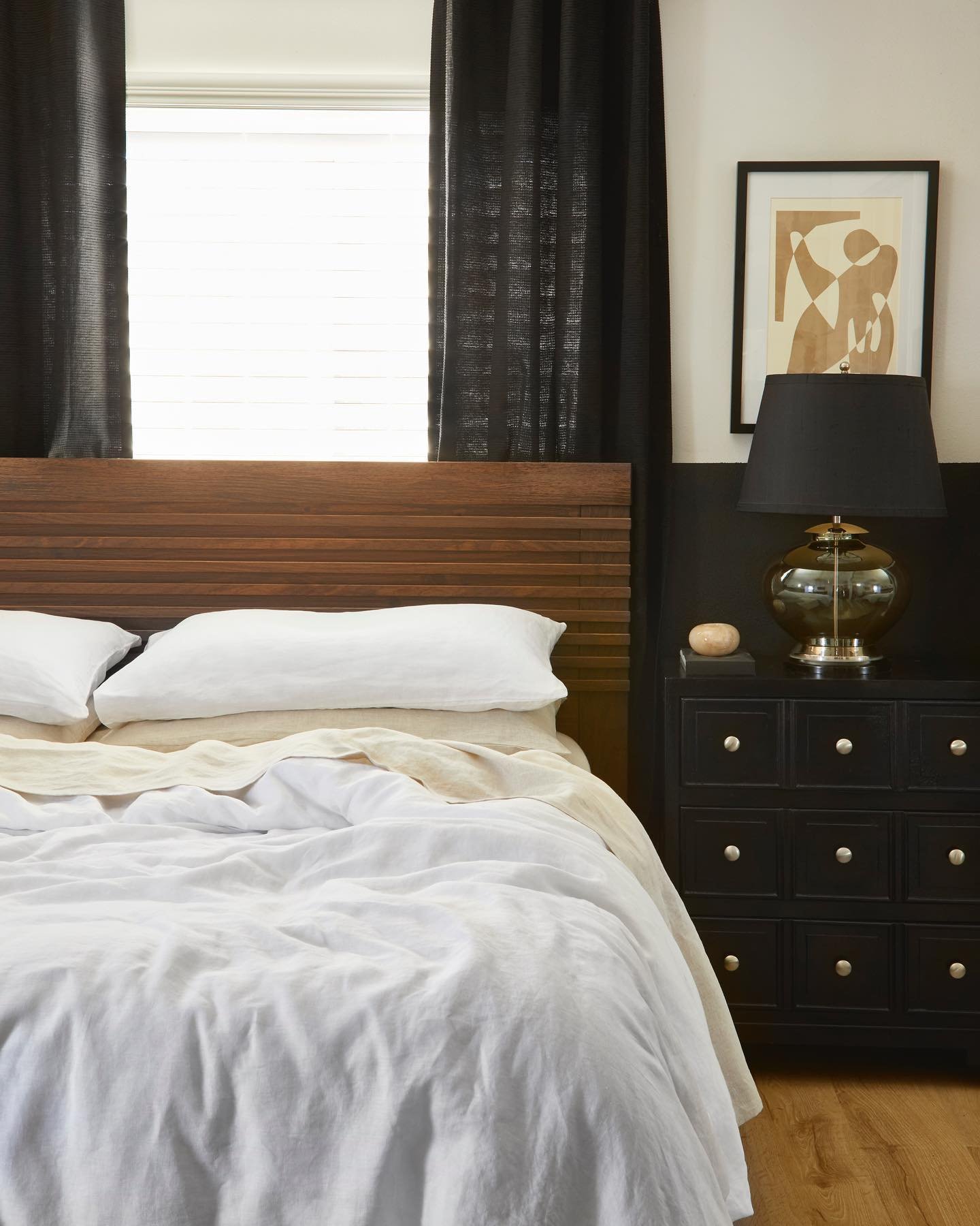 Bedroom with wood slat headboard and black nightstand