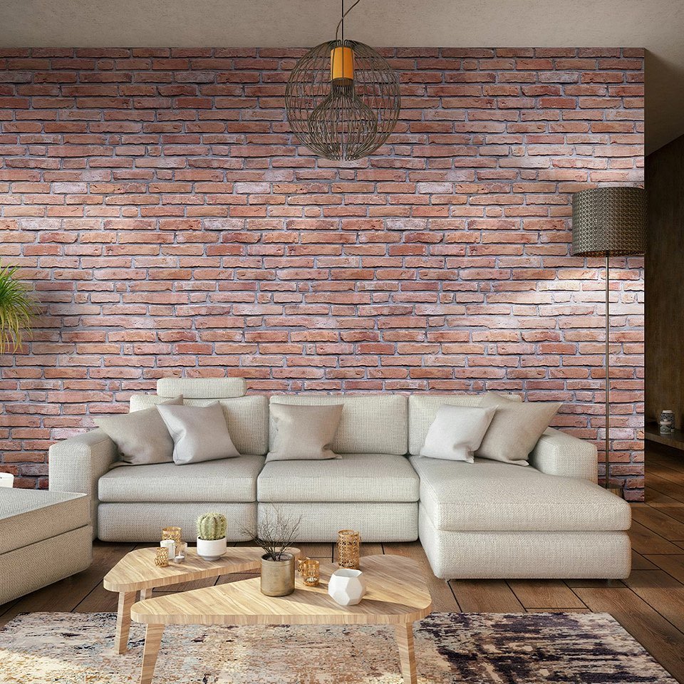 Full wall covered in red exposed brick behind a modern beige sofa