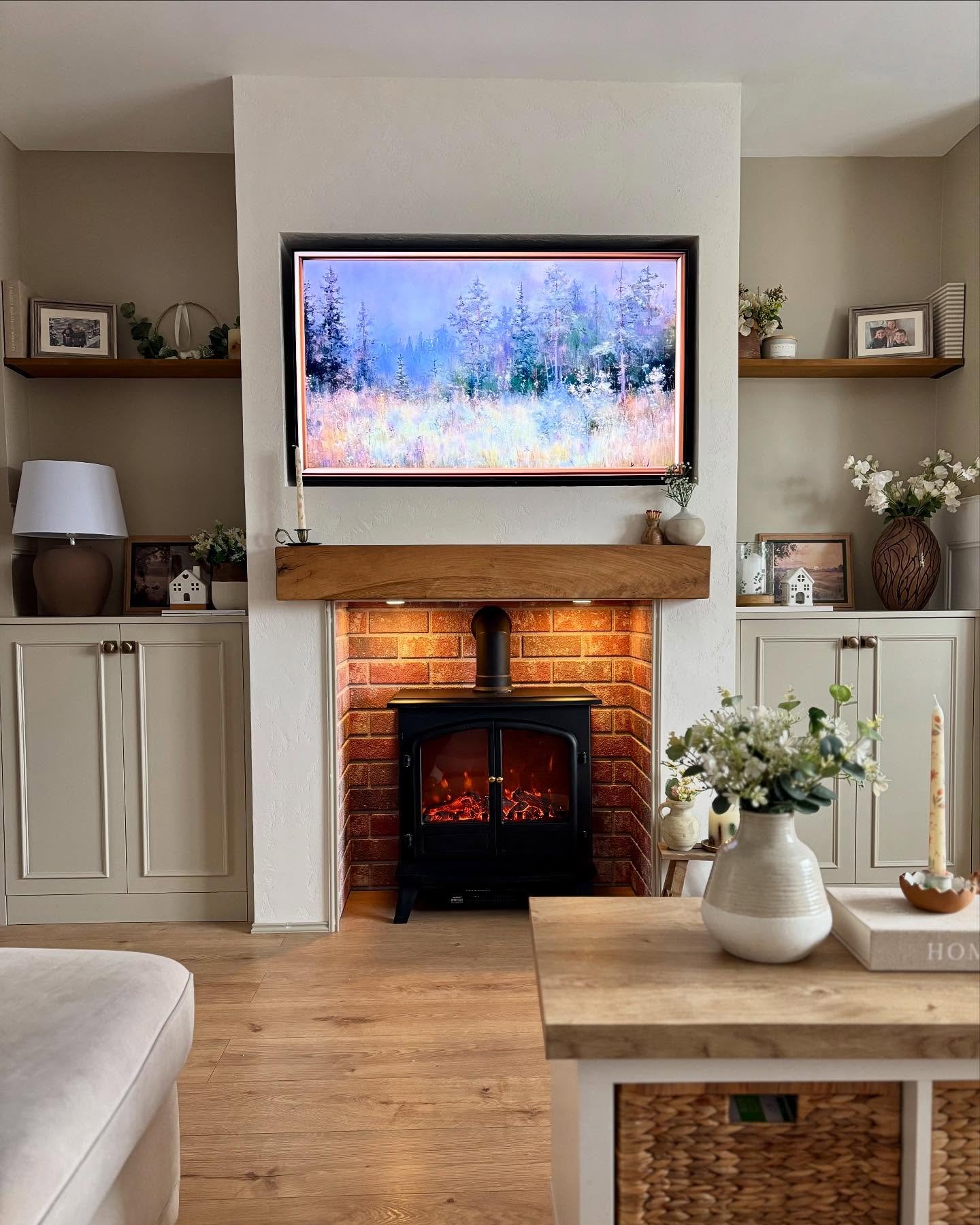 Beige alcove cabinets with single wood floating shelves flanking a red brick fireplace.