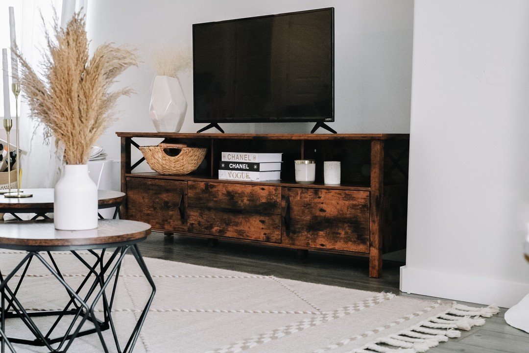 Dark wood TV console with X-frame sides and lower cabinets