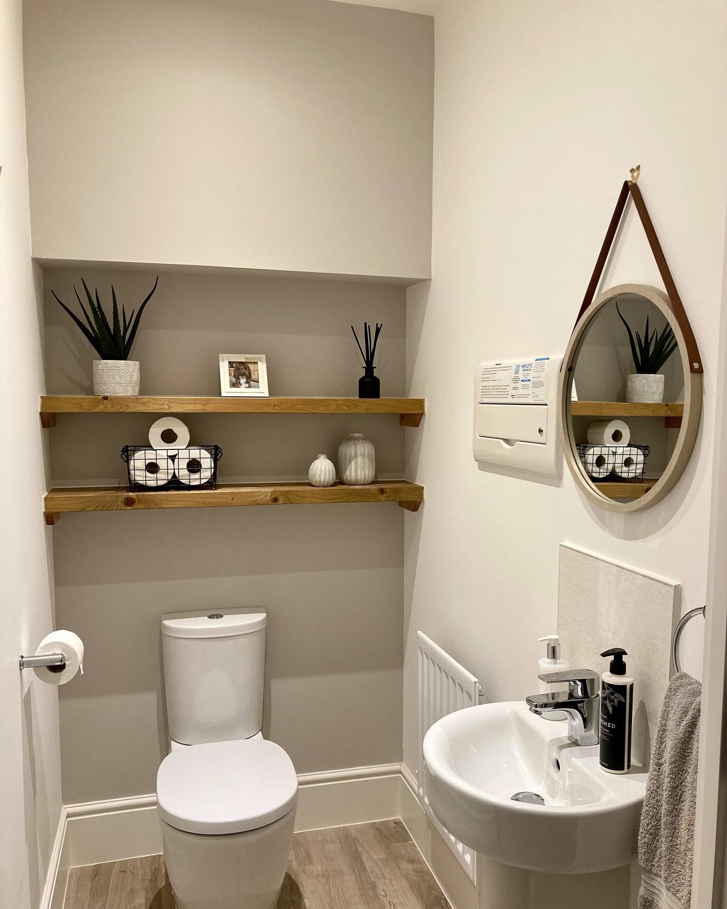 Two stained wood shelves installed in a grey bathroom alcove above the toilet