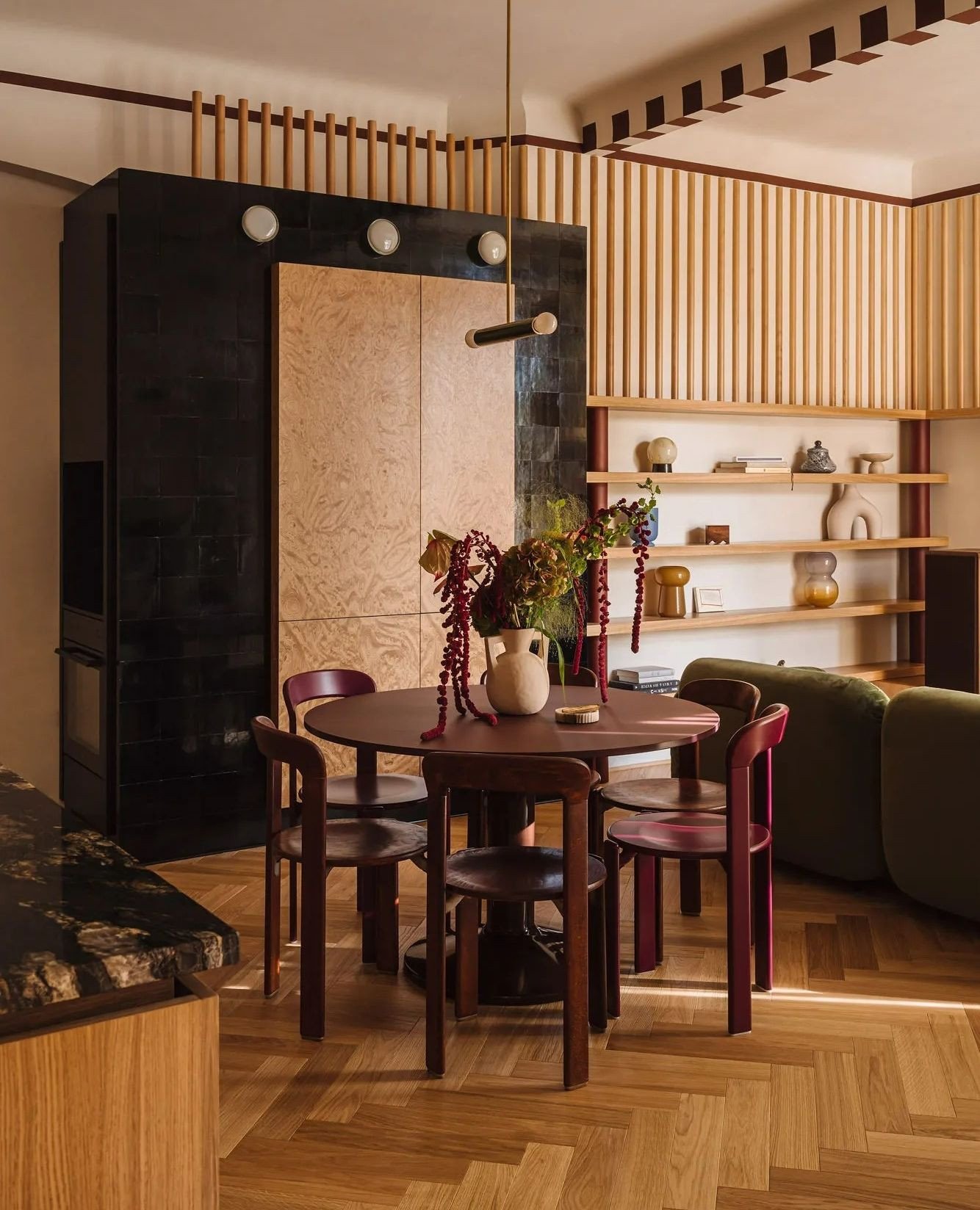 Dark burgundy round kitchen table with matching curved wooden chairs on herringbone floor