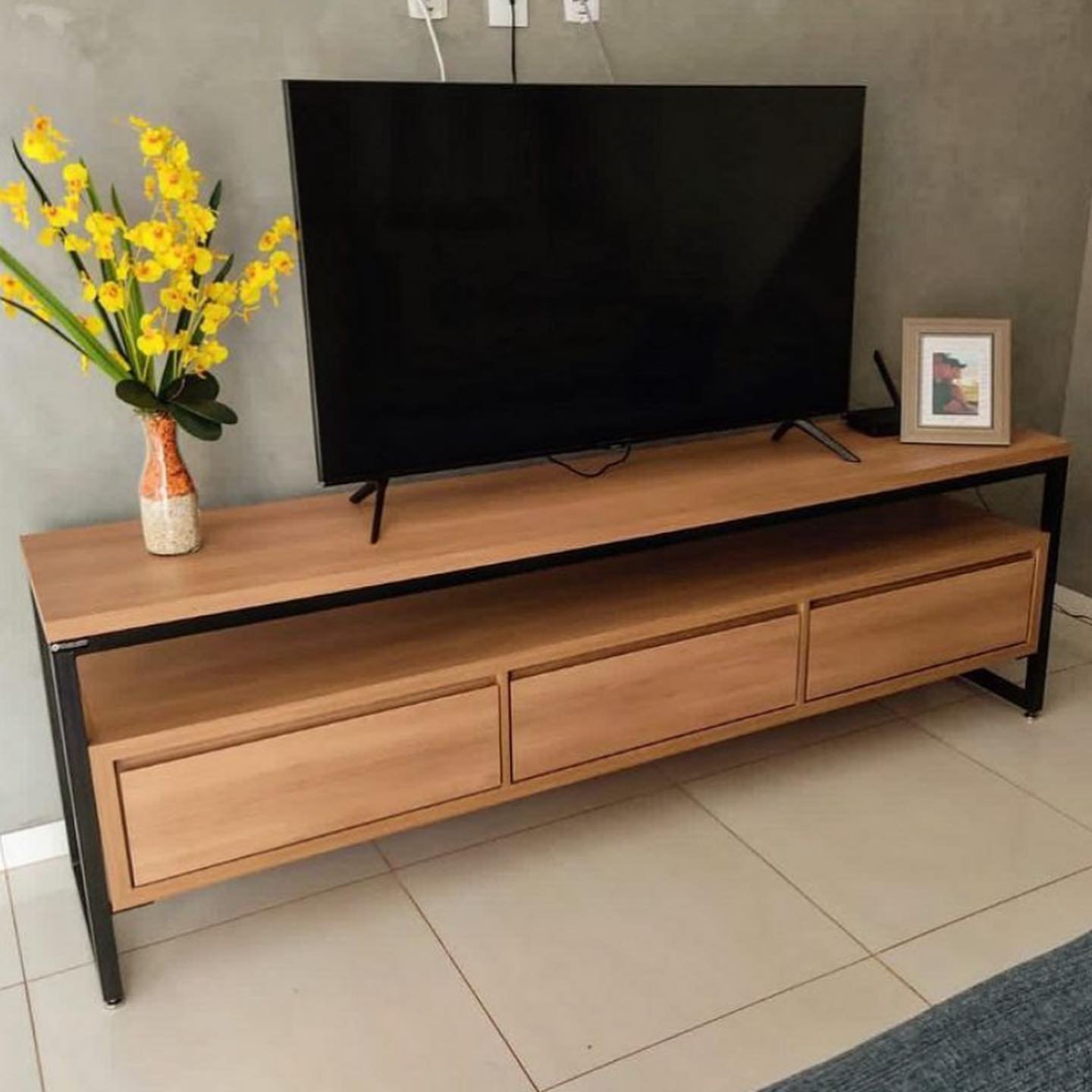 Long light wood TV stand with black metal frame and three drawers
