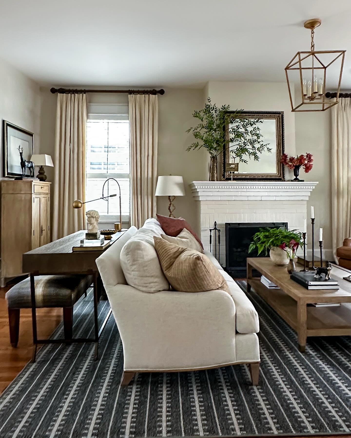 Wooden desk with bench used as a sofa table in a living room