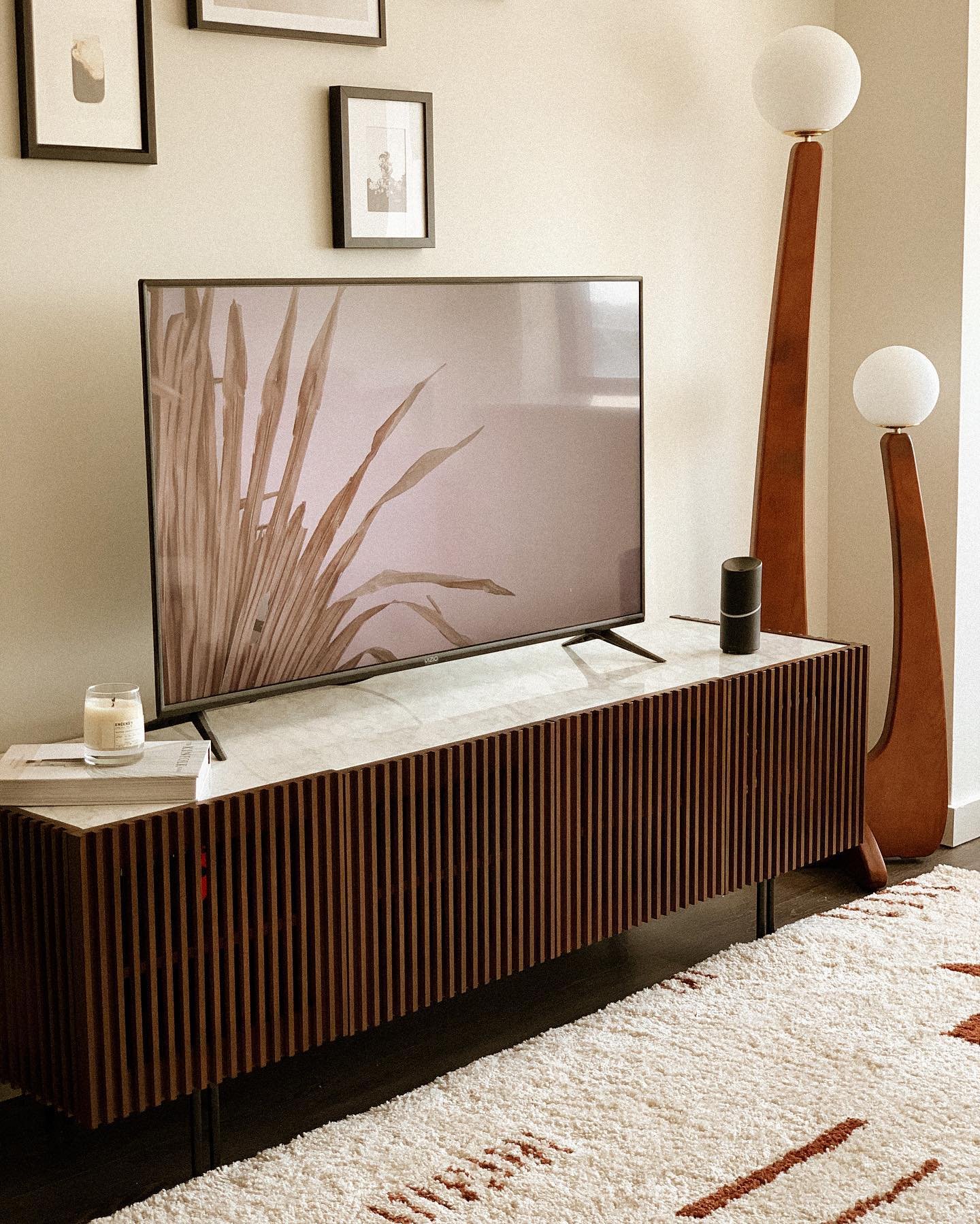 Dark wood TV console with vertical slats and white stone top