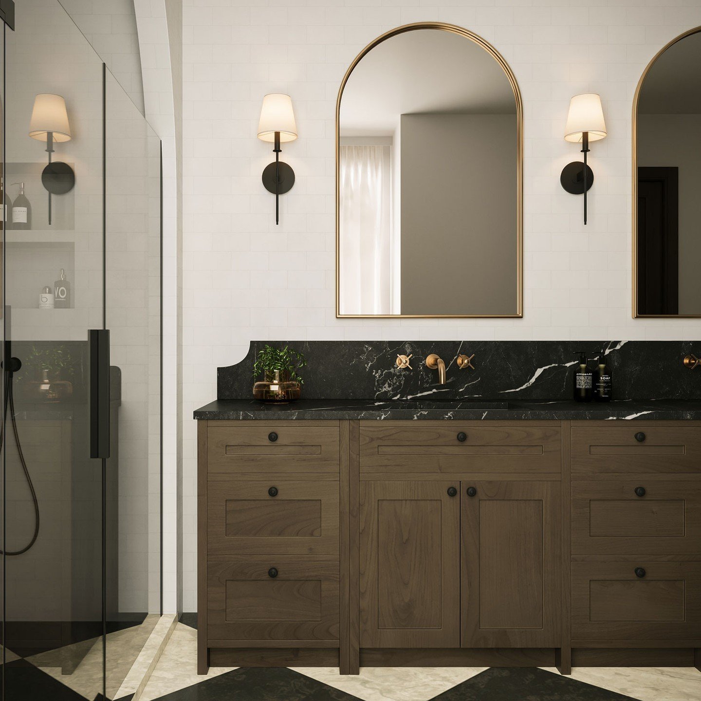 Black wall sconces with white tapered fabric shades flanking a gold-framed arched mirror above a dark wood vanity with black marble counter.