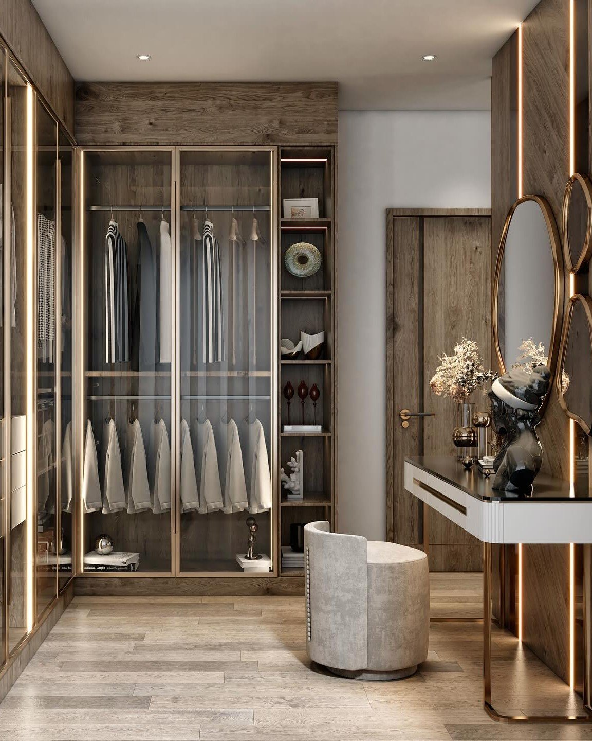 A luxury walk-in closet featuring rustic-toned wood cabinetry with glass doors, a modern vanity area with multiple mirrors, and brushed gold accents.