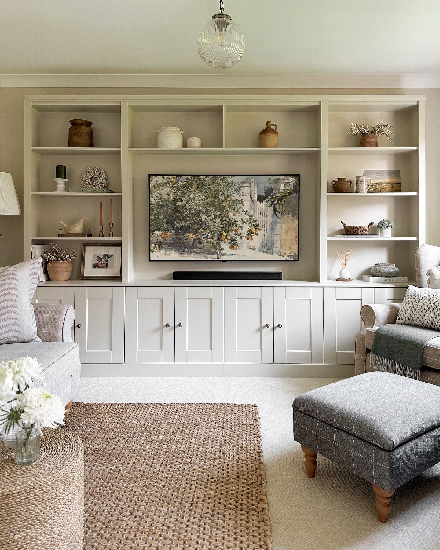 Cream wall-to-wall built-in media unit with shaker cabinets and open shelves