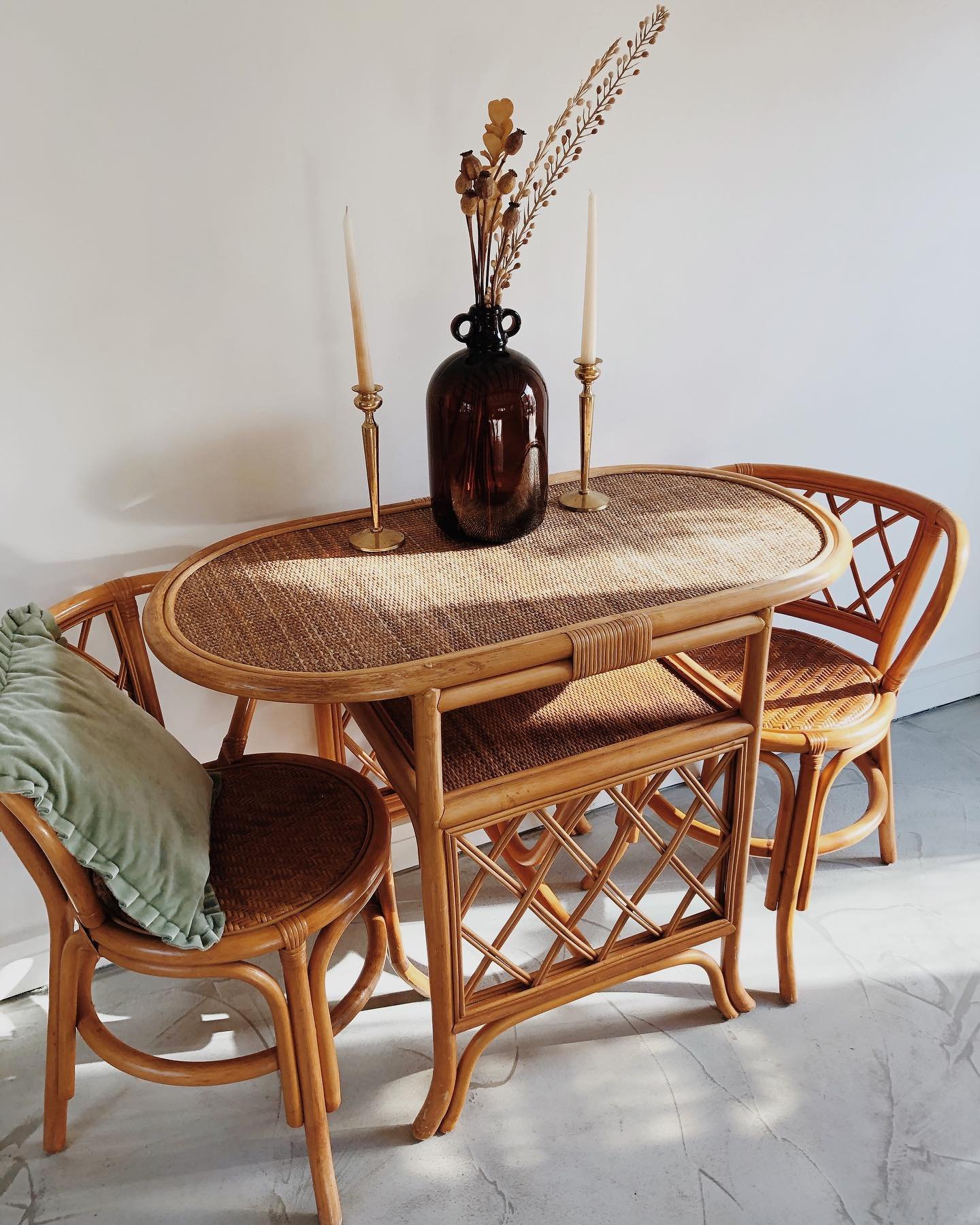 Small oval rattan dining table with woven top and matching cane chairs
