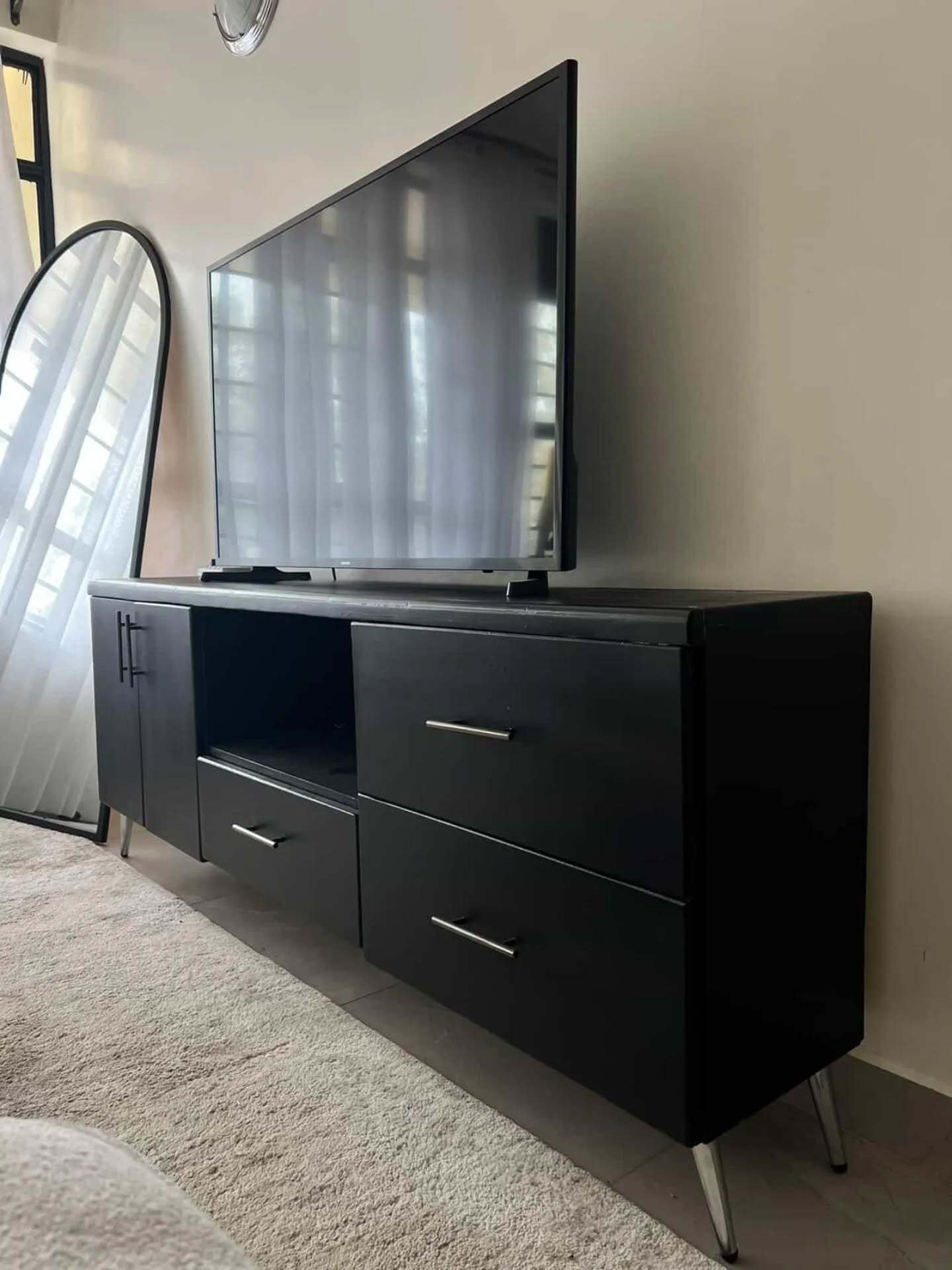 Black modern TV stand with silver handles and chrome legs