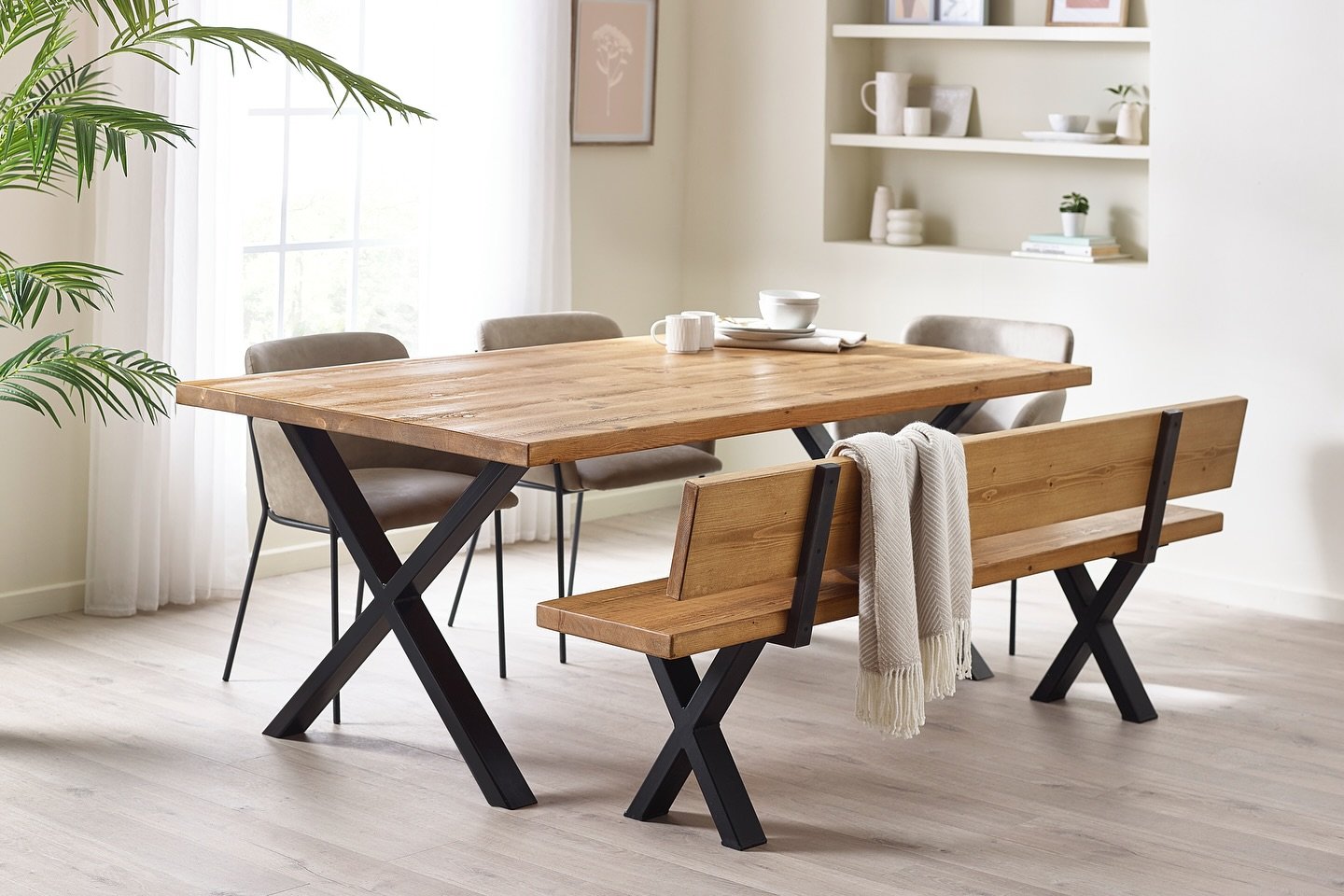Wooden dining table with black metal cross legs and matching bench