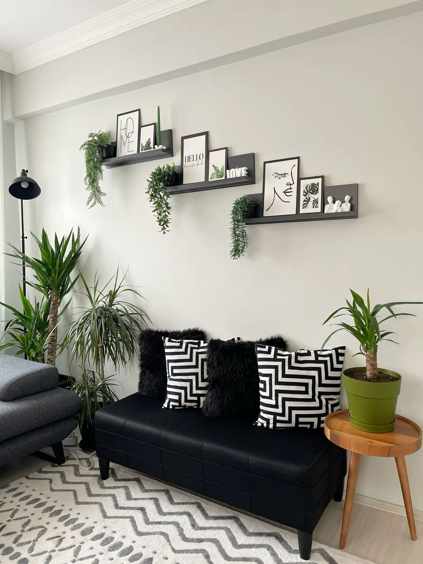 Three black floating picture shelves arranged diagonally holding art frames