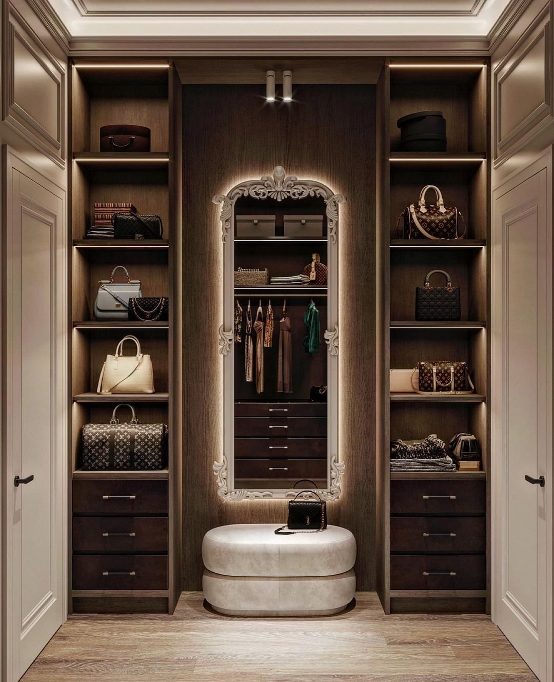 A small, luxury dressing room featuring dark wood shelving for designer handbags, a central ornate mirror with backlighting, and a cushioned ottoman.