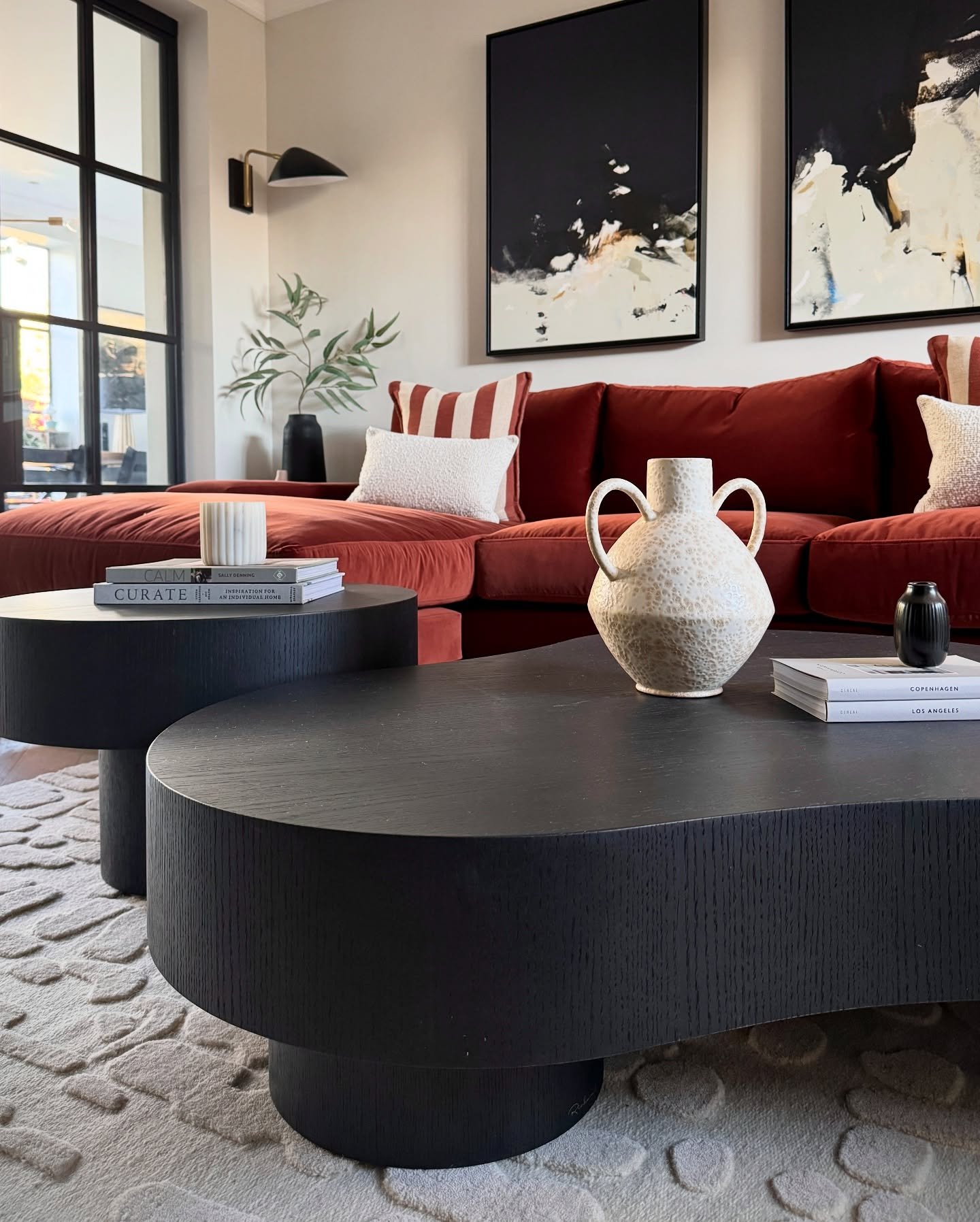 Two black organic shaped coffee tables with textured wood finish
