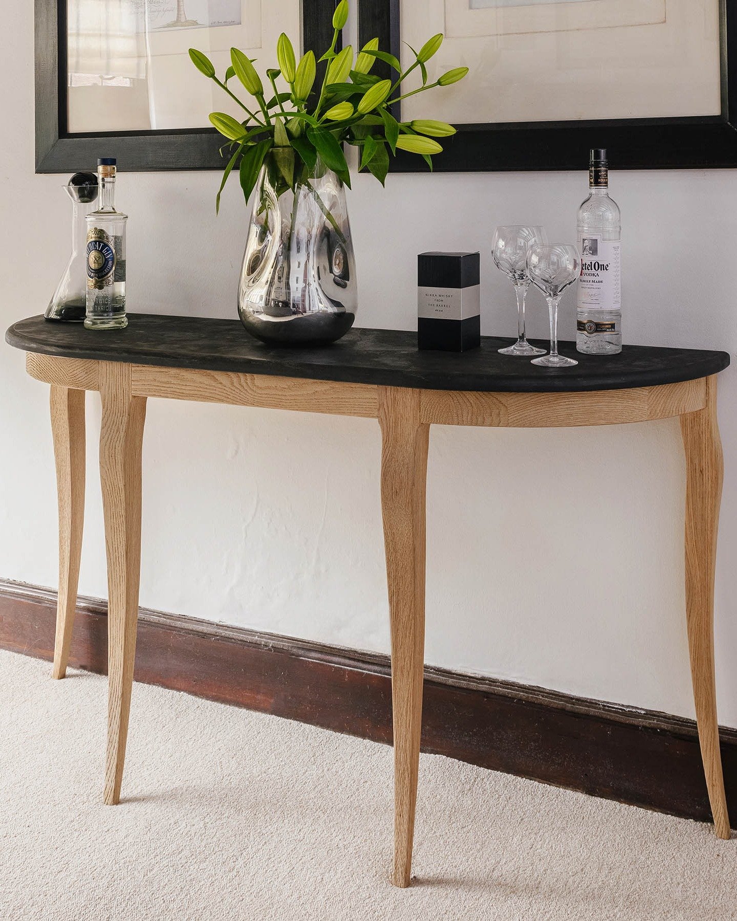Half-moon hallway table with black top and light wood legs