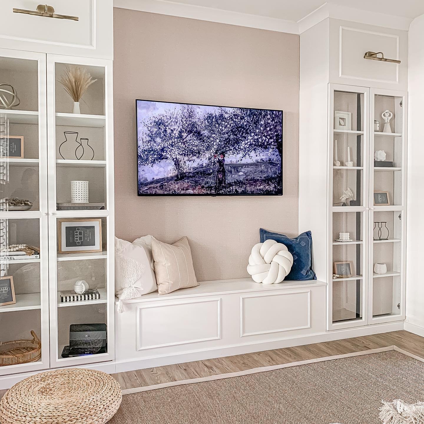 White floor-to-ceiling built-in cabinets with glass doors flanking a central bench seat