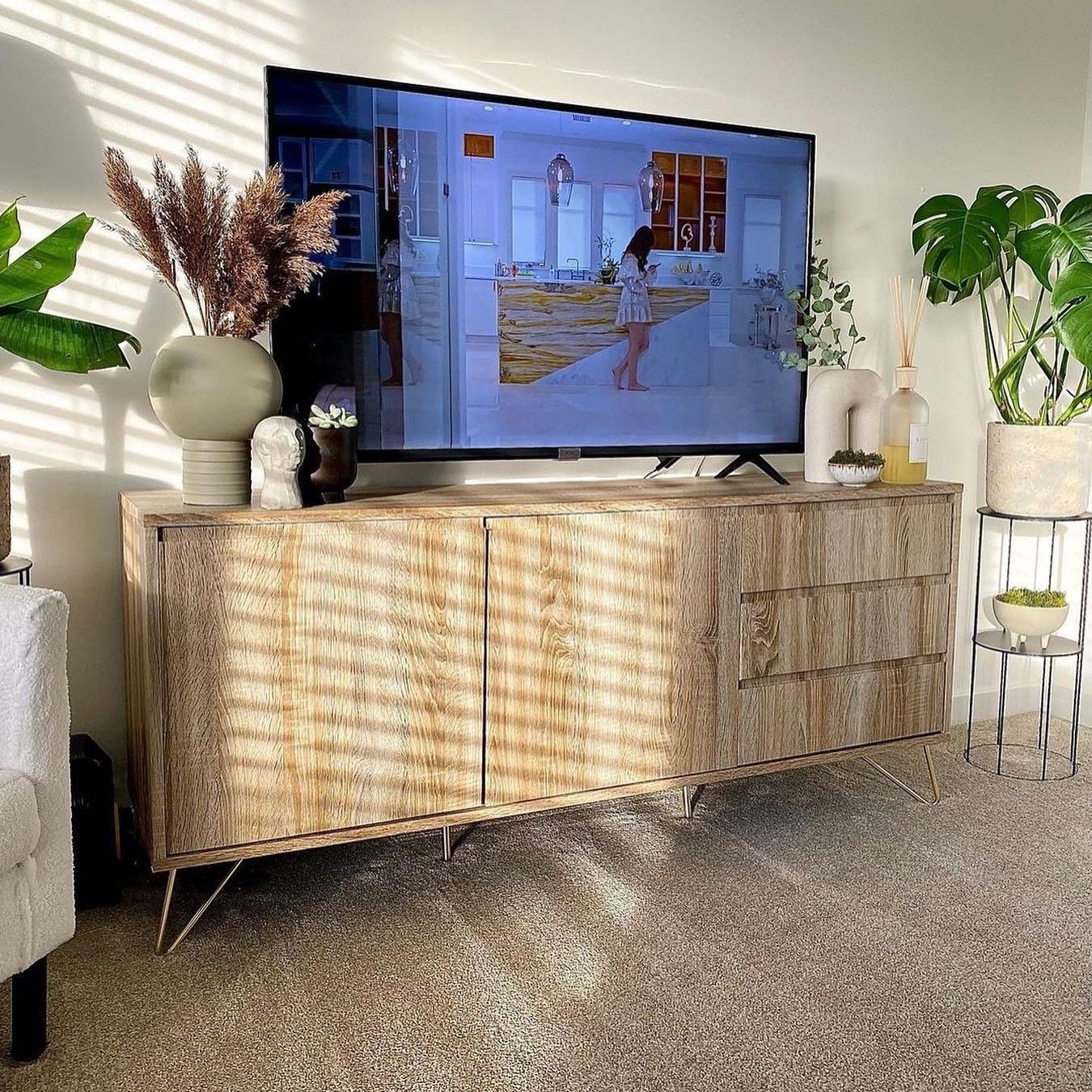 Light oak TV stand with three drawers and hairpin legs