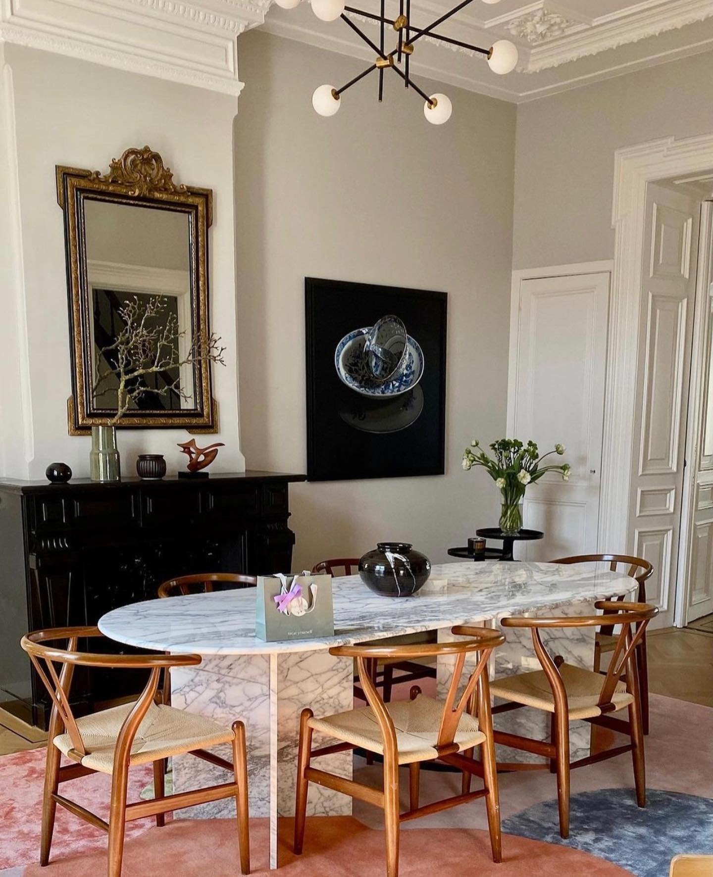 White marble oval dining table with wooden wishbone chairs