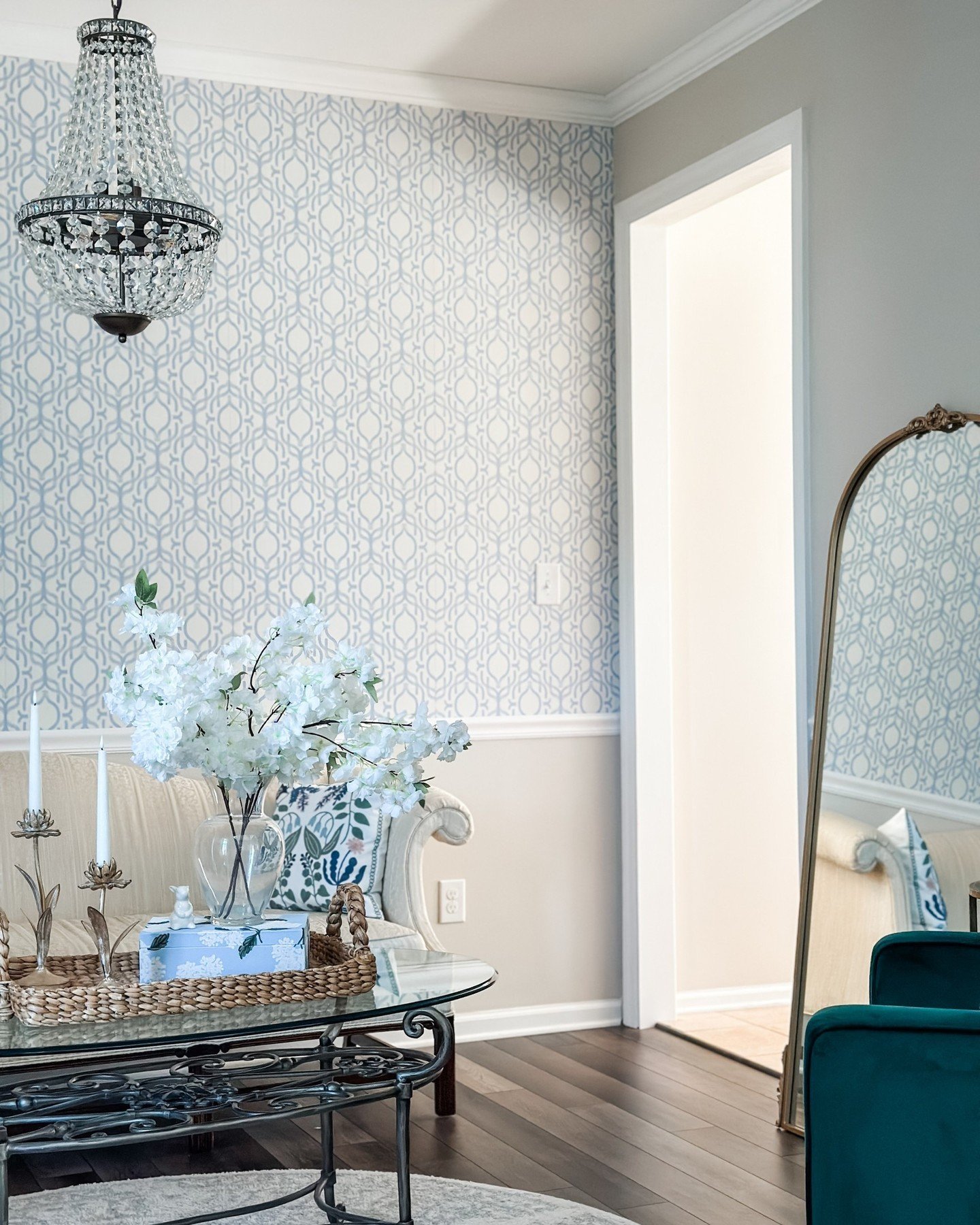 Blue geometric wallpaper applied above a white chair rail molding