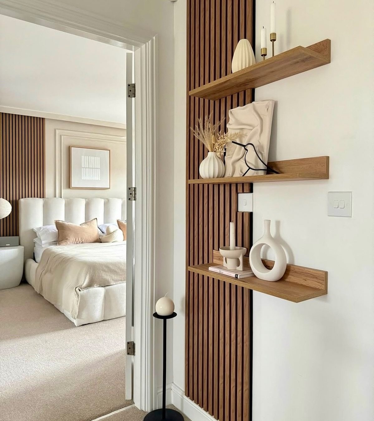 Wooden floating ledge shelves mounted across a vertical slat wall panel