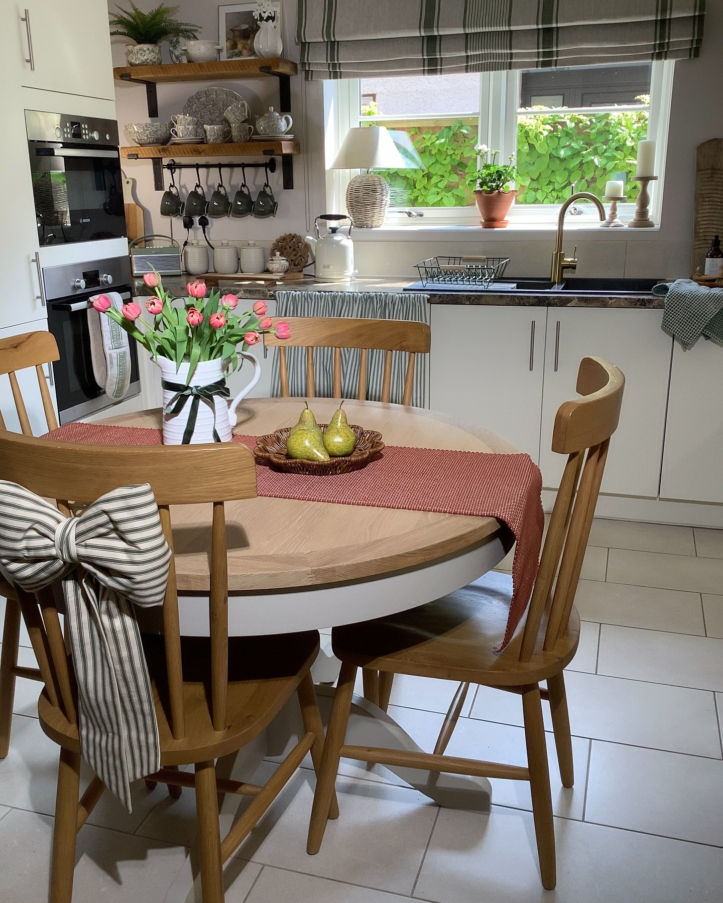 Round kitchen table with oak top and white painted base with wooden chairs