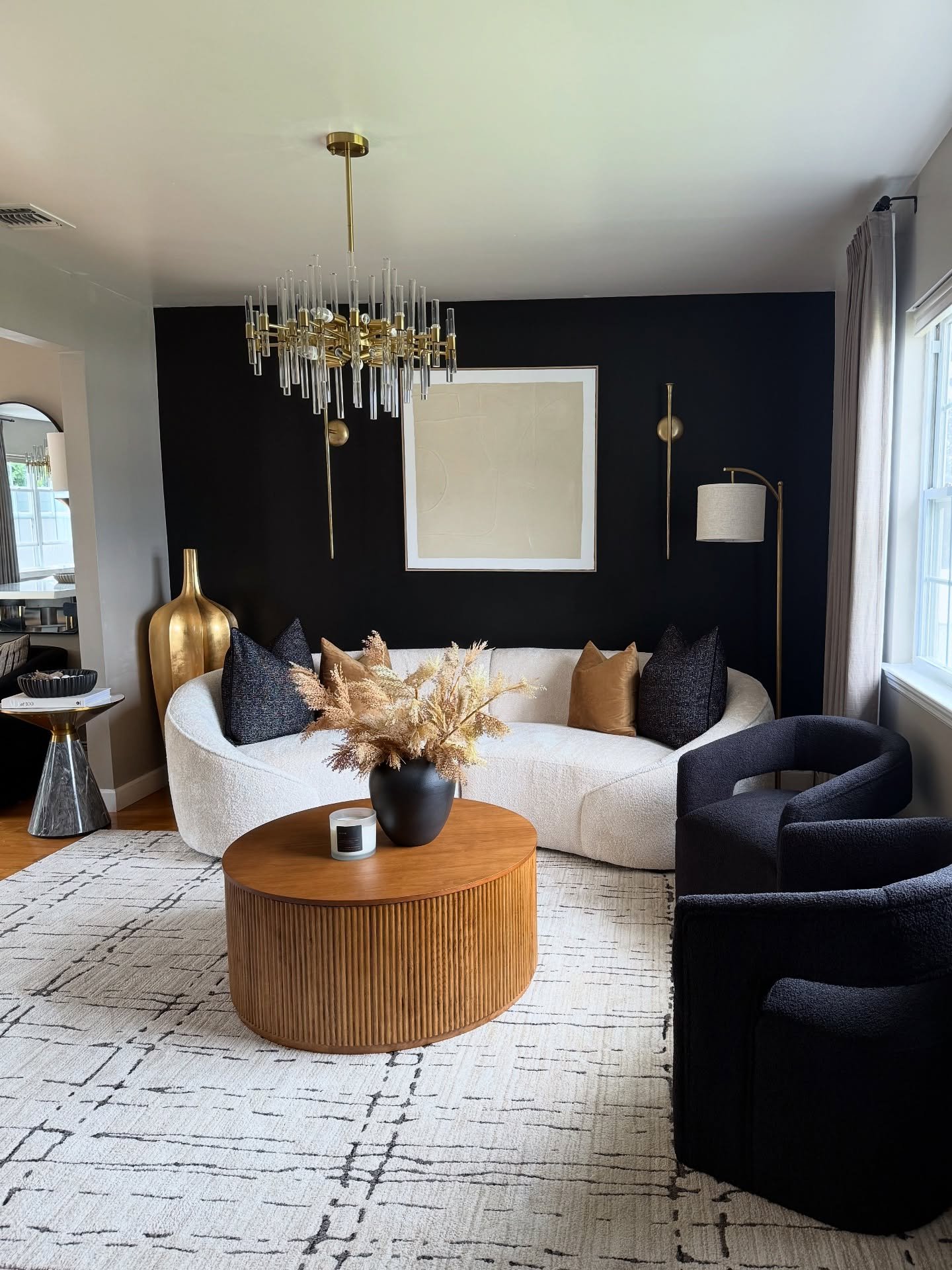 Solid matte black accent wall contrasting with white ceiling and gold sconces