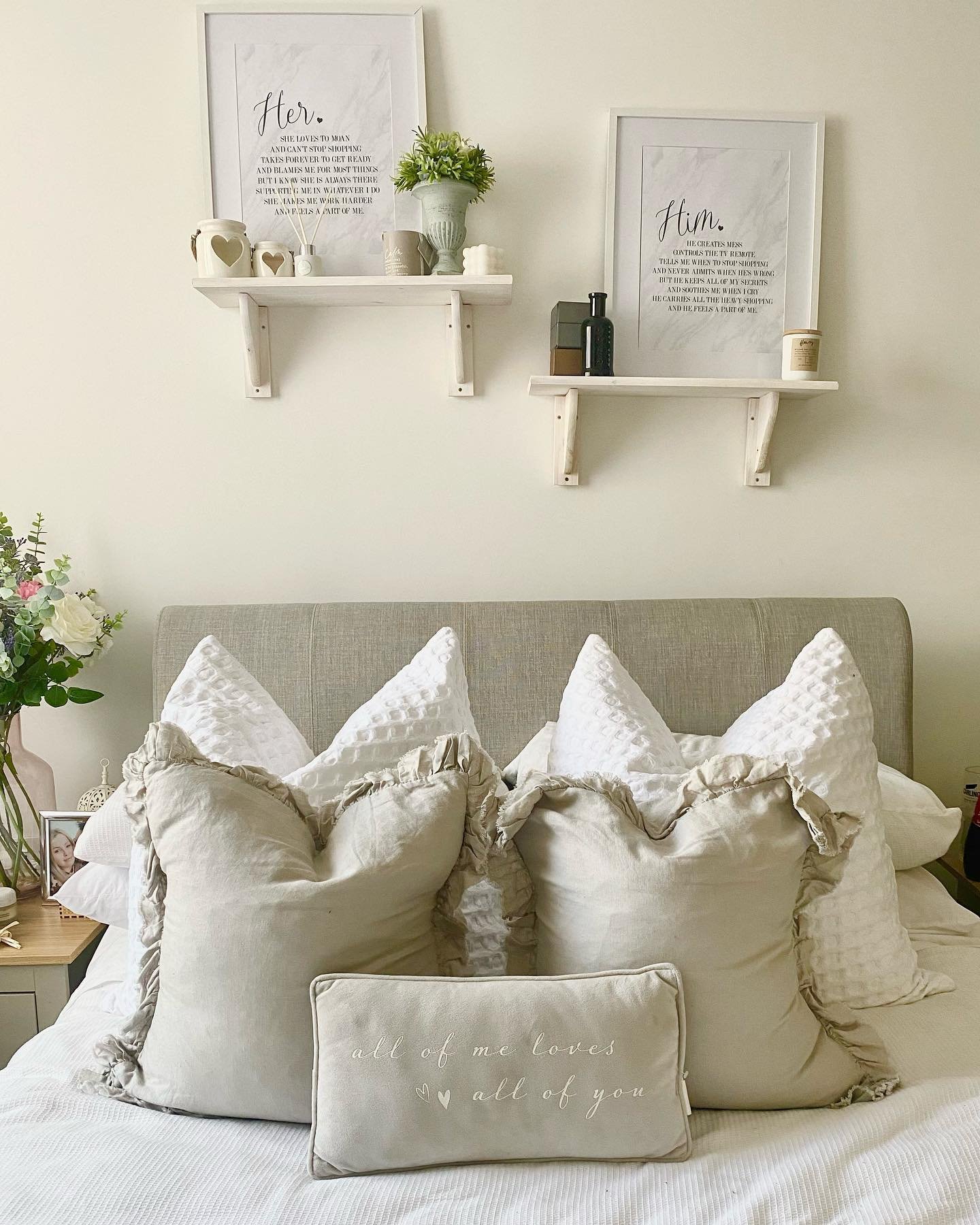 Two small white shelves mounted with brackets holding him and her art.