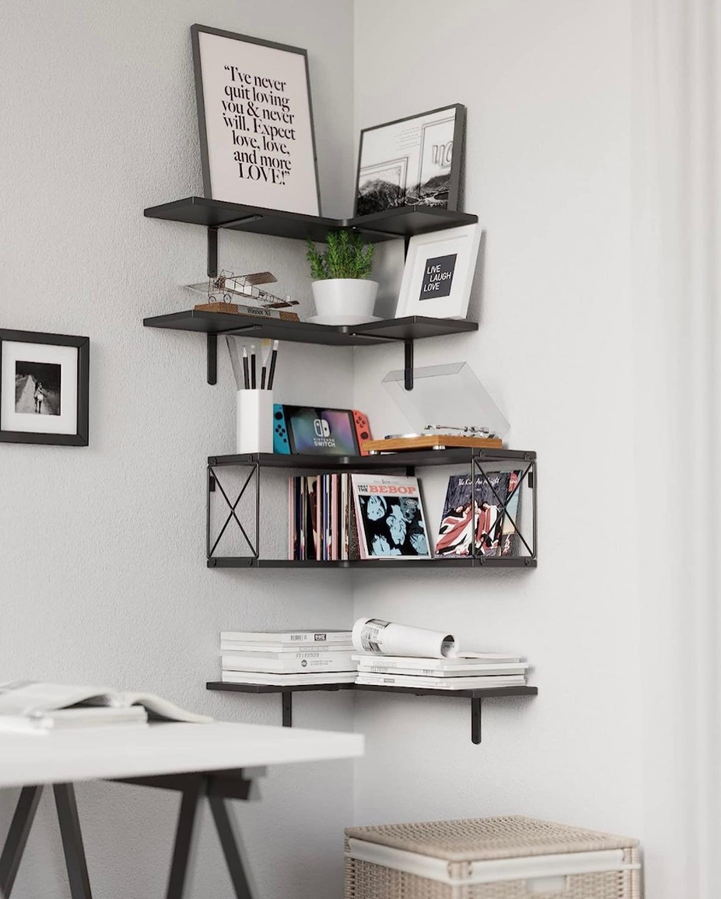 Black industrial style corner shelves featuring a central wire cage unit and flat floating tiers.