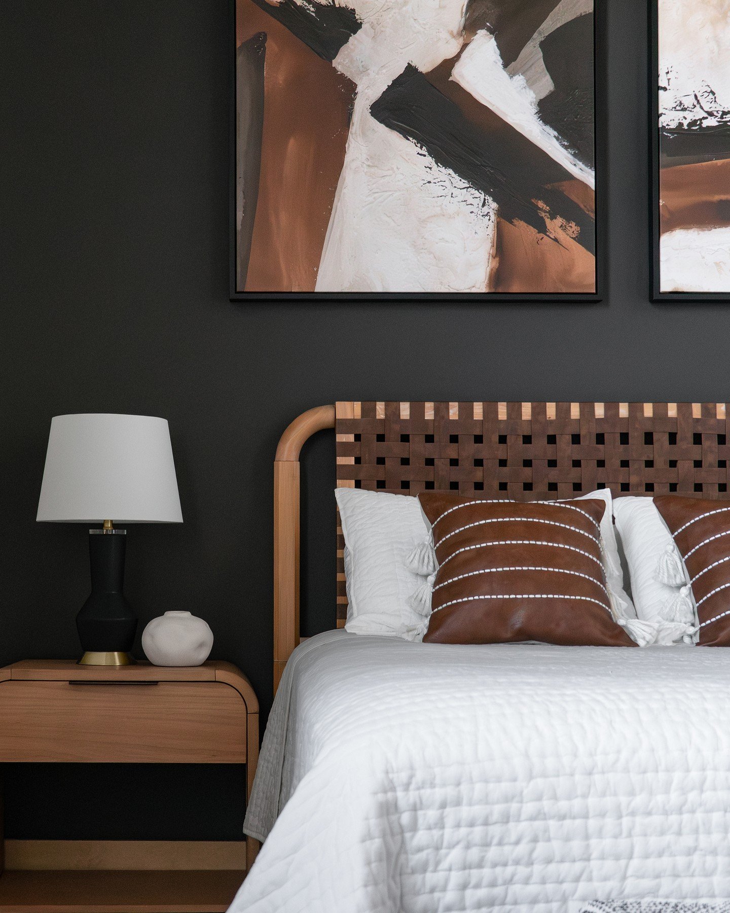 Bedroom with woven leather headboard and abstract art