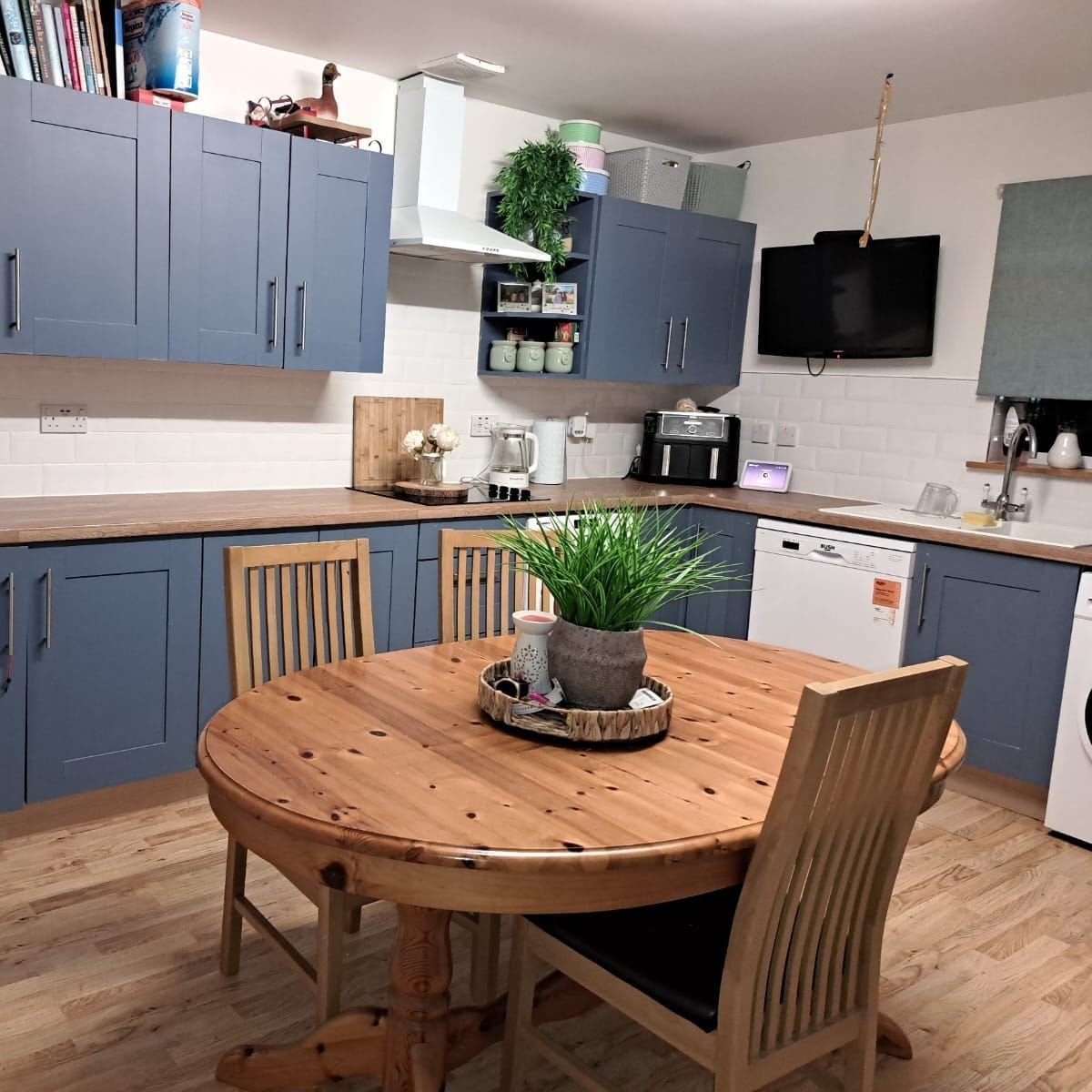 Round pine wood kitchen table with pedestal base and wooden chairs