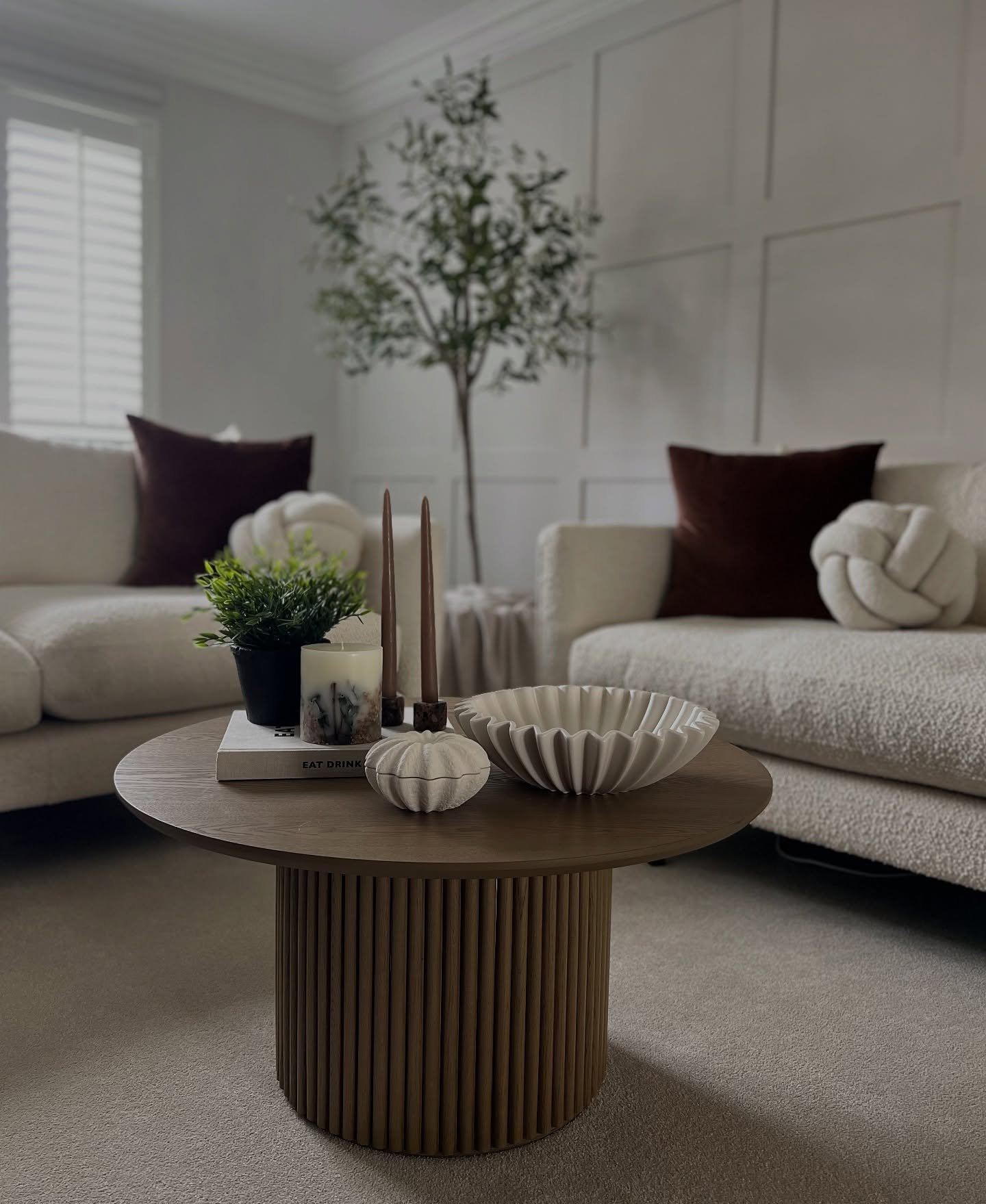 Round coffee table with fluted cylinder base in a cozy lounge