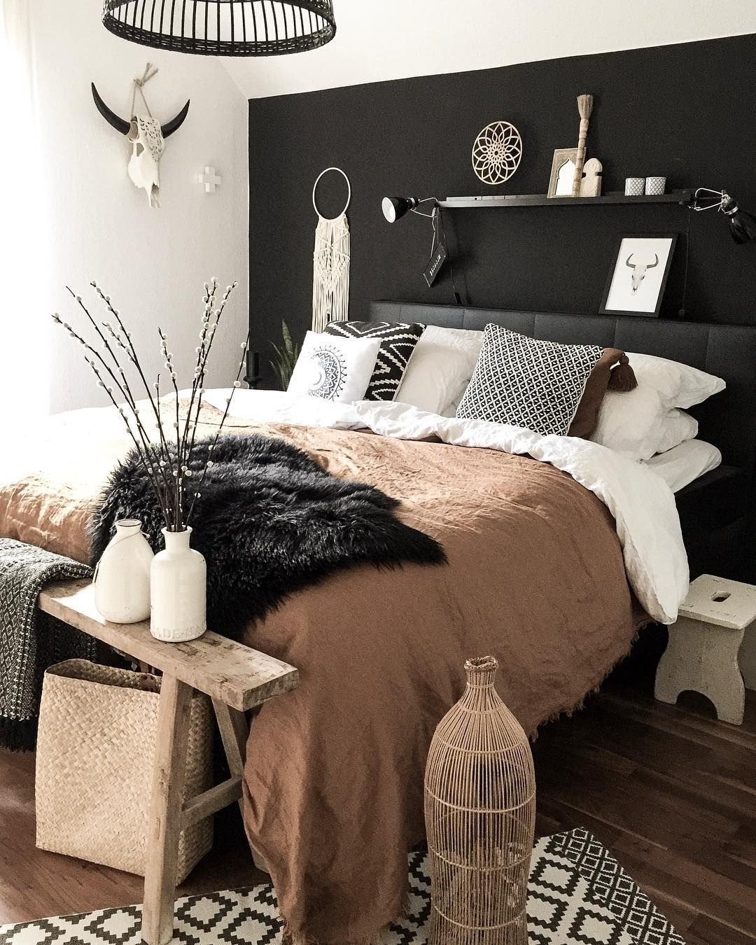 Black bedroom wall with brown bedding and boho decor