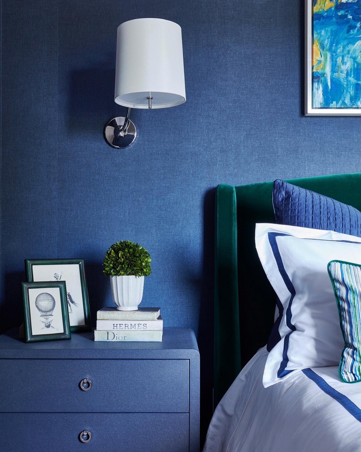 Navy blue grasscloth wallpaper accent wall with matching textured nightstand