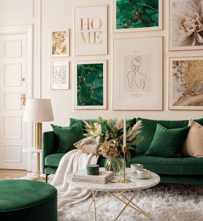 Gallery wall featuring gold frames with abstract green art and line drawings above a green sofa.