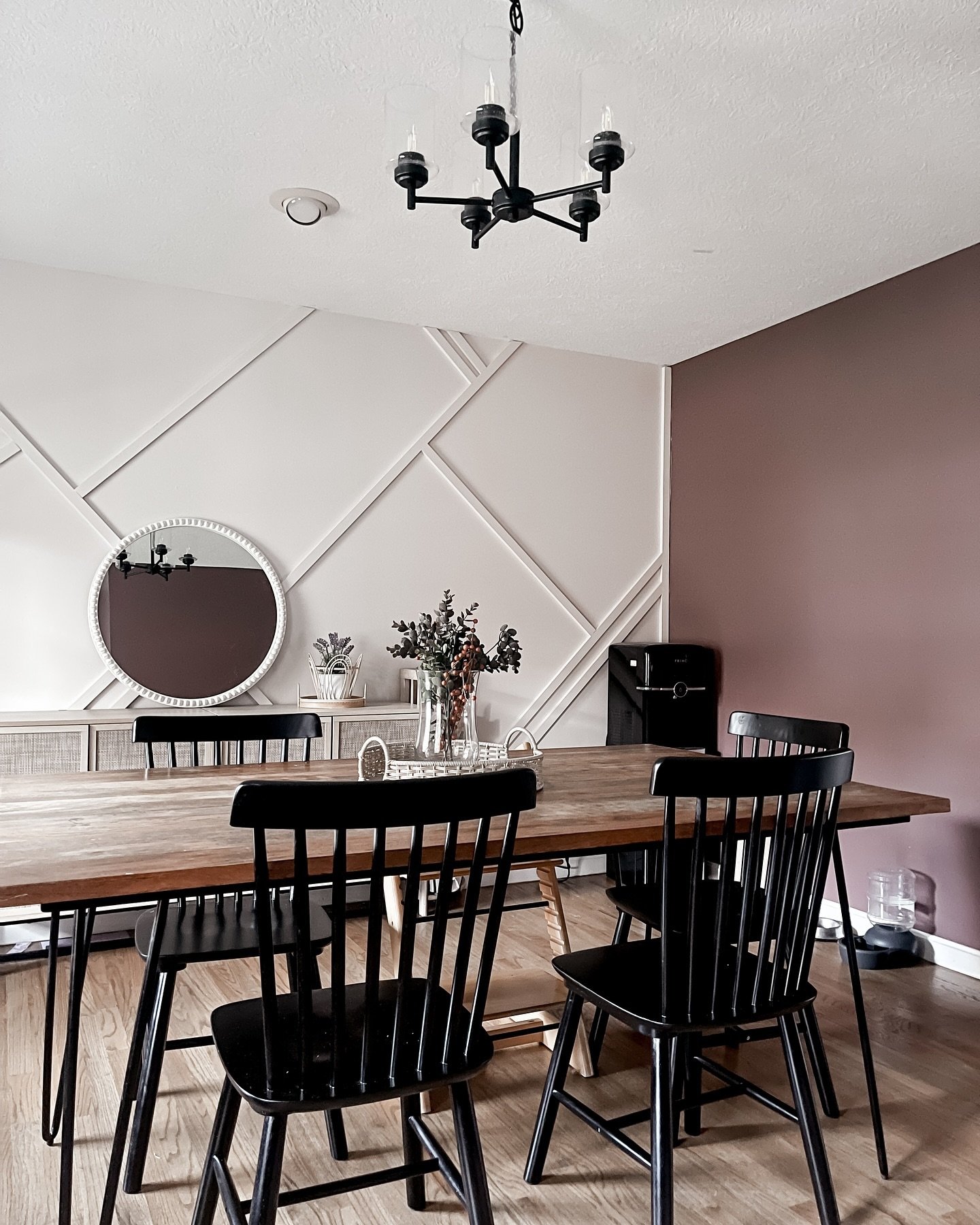 Beige asymmetrical geometric accent wall paired with a mauve painted wall in a dining room.