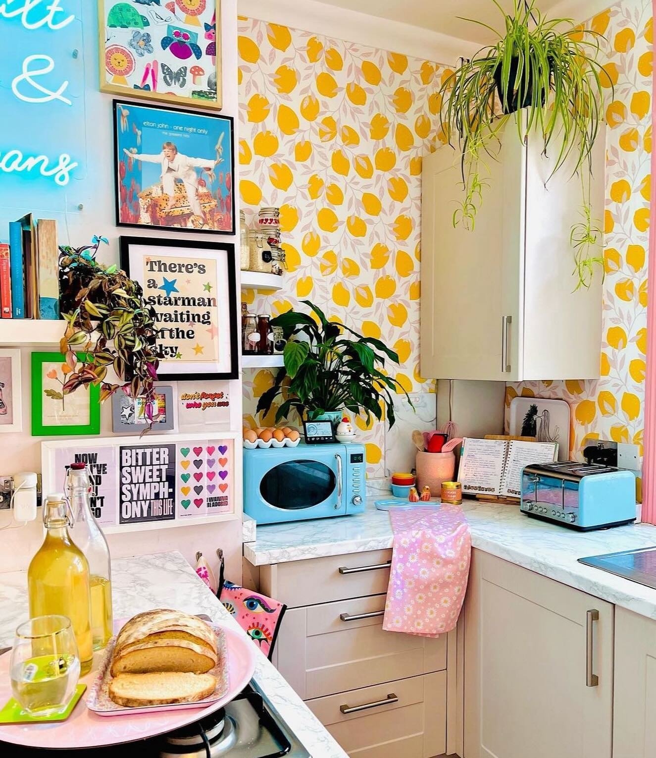 Colorful kitchen corner with lemon wallpaper and bright pop art gallery wall