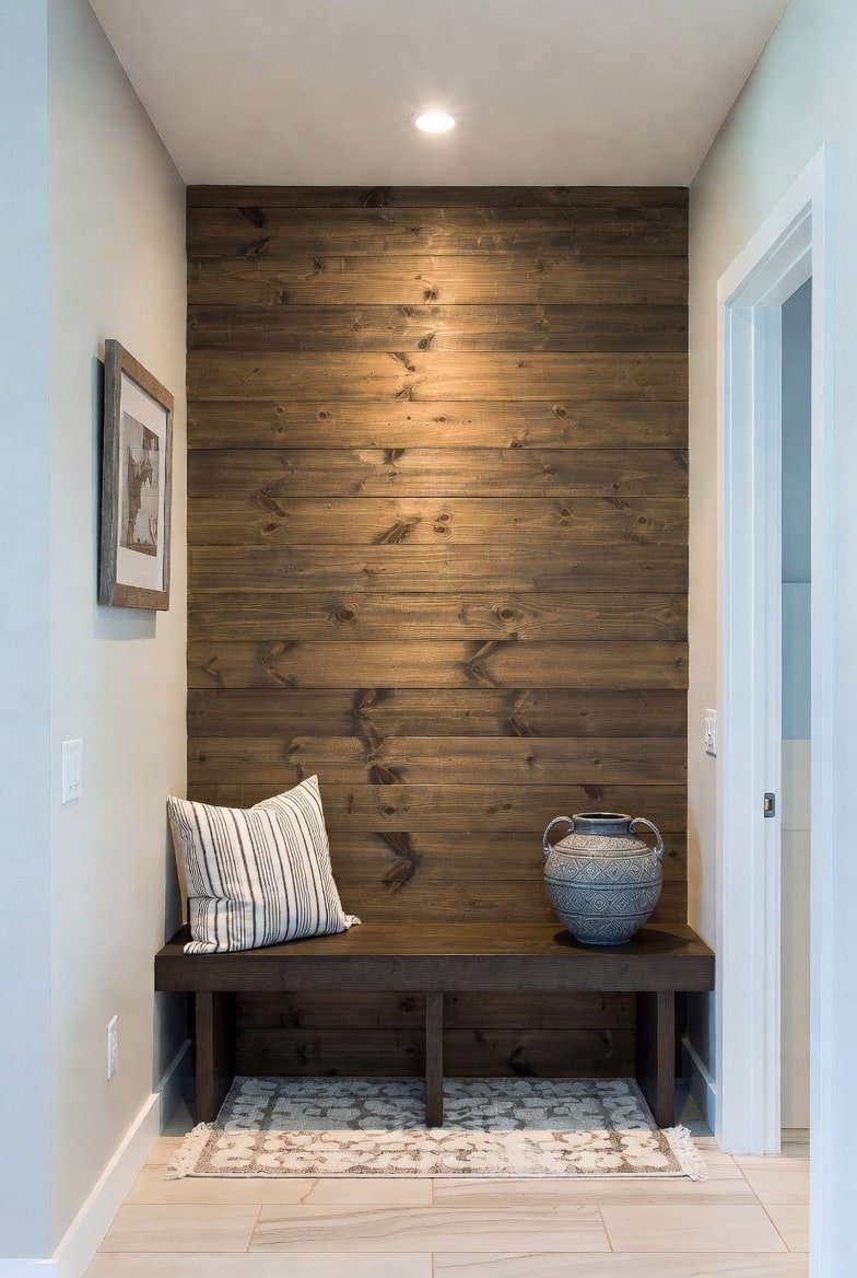 Rustic Hallway Nook Alt Text: Small hallway alcove featuring a dark wood horizontal plank accent wall behind a bench.
